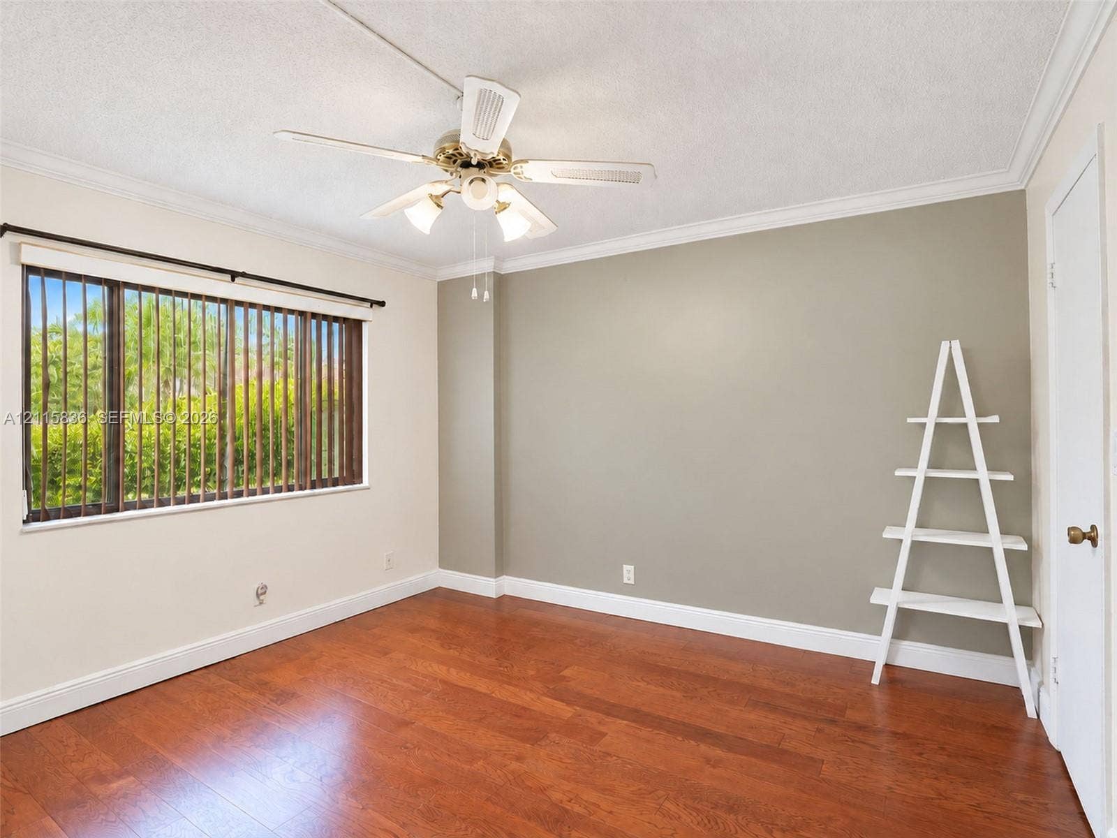 8000 Hampton Boulevard, #311, North Lauderdale, North Lauderdale, FL 33068 Room featuring wood-finish flooring, a multi-blade ceiling fan with integrated lighting, crown molding, and a wide window with vertical blinds