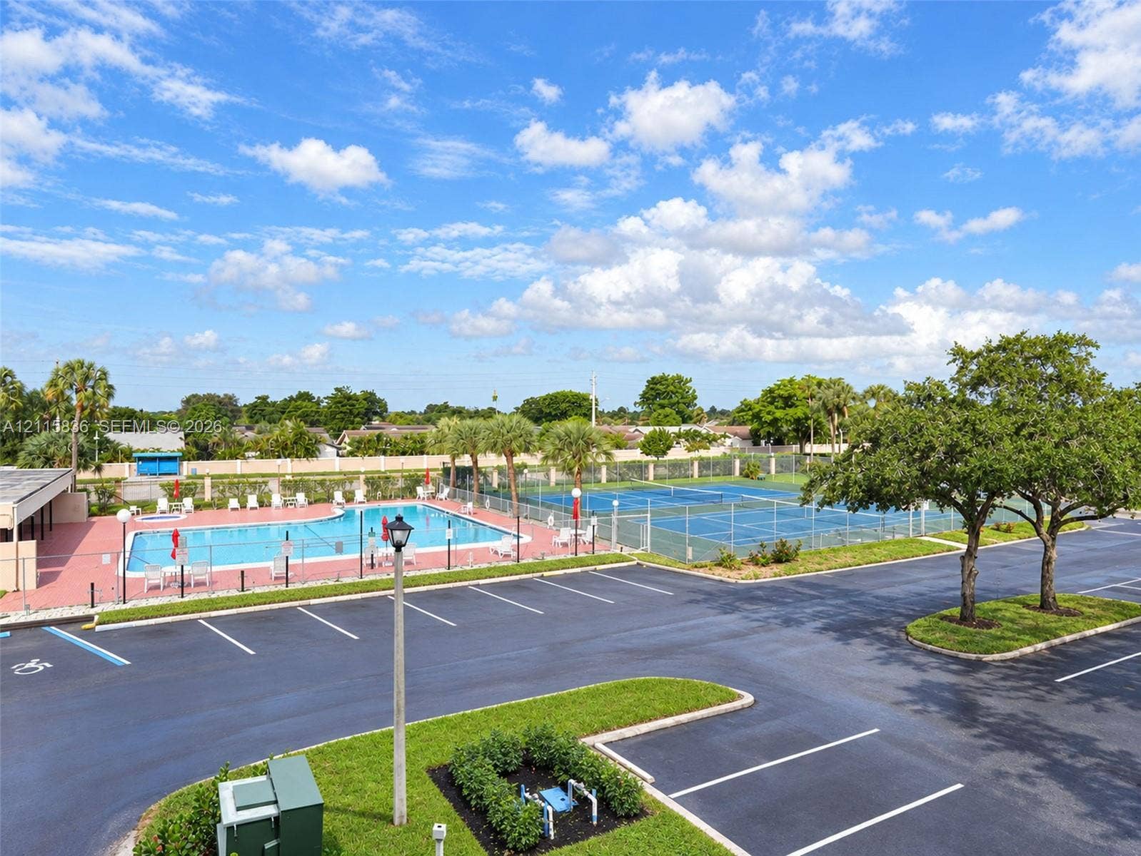 8000 Hampton Boulevard, #311, North Lauderdale, North Lauderdale, FL 33068 Recreational area featuring a fenced swimming pool and dual tennis courts with hard-court surfaces