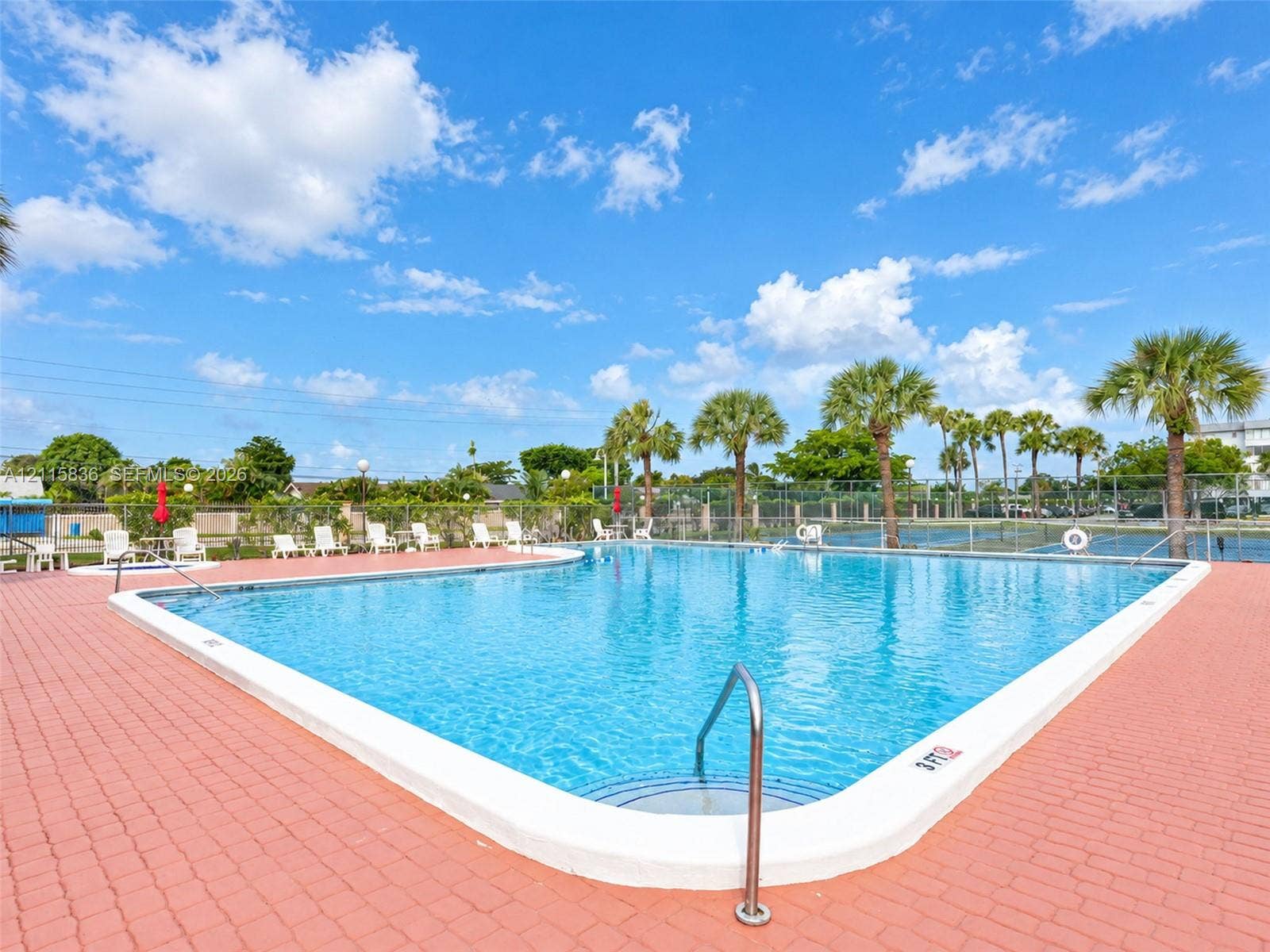 8000 Hampton Boulevard, #311, North Lauderdale, North Lauderdale, FL 33068 Outdoor swimming pool featuring a red brick paver deck, metal entry railings, and surrounding palm trees