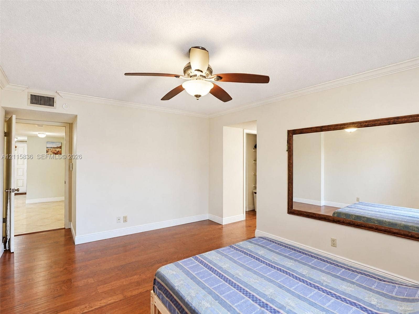 8000 Hampton Boulevard, #311, North Lauderdale, North Lauderdale, FL 33068 Wood-finish flooring, ceiling fan with integrated lighting, and wall-mounted oversized mirror with a decorative frame