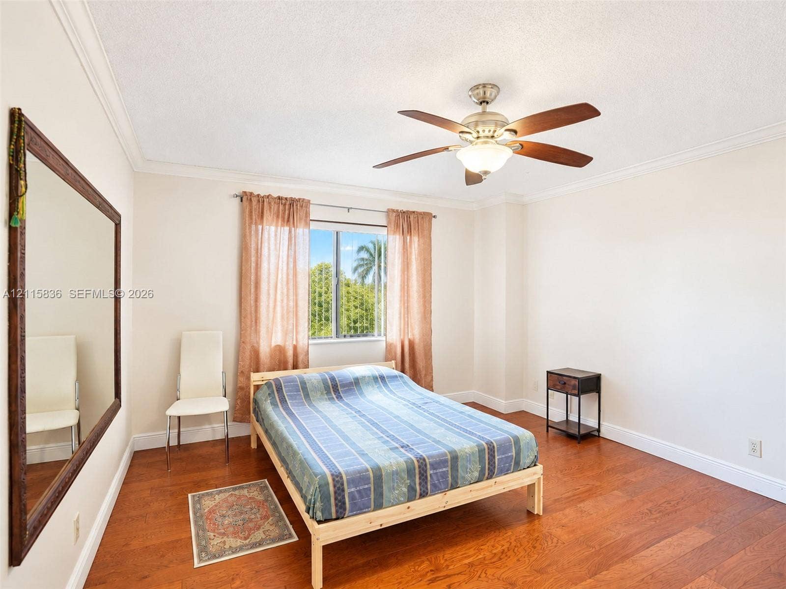 8000 Hampton Boulevard, #311, North Lauderdale, North Lauderdale, FL 33068 Wood-finish flooring, crown molding, multi-blade ceiling fan with integrated lighting, and a large-format wall mirror with a wood frame