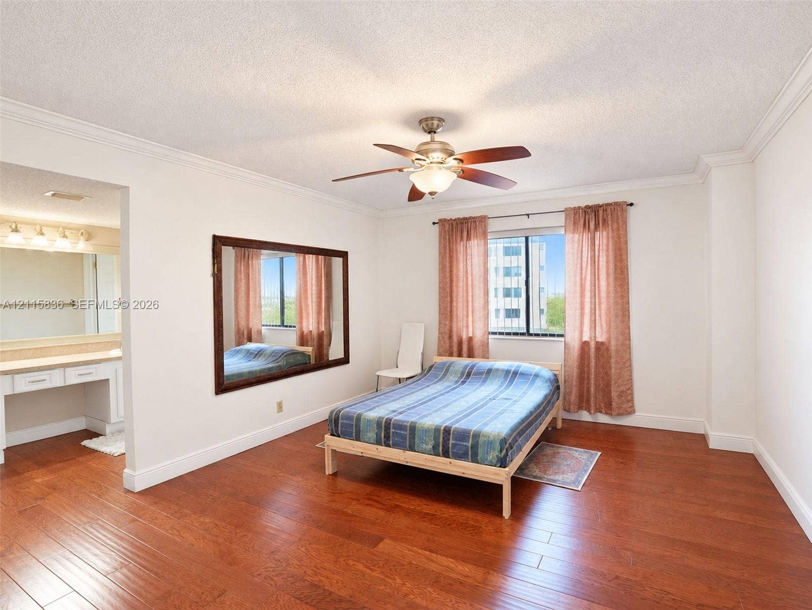 8000 Hampton Boulevard, #311, North Lauderdale, North Lauderdale, FL 33068 Wood-finish flooring, ceiling fan with integrated lighting, wall-mounted mirror, crown molding, and built-in vanity with countertop
