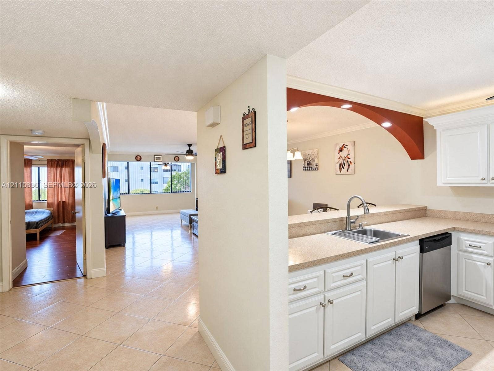 8000 Hampton Boulevard, #311, North Lauderdale, North Lauderdale, FL 33068 Kitchen featuring white cabinetry, stone-finish countertops, stainless steel sink with arched faucet, and stainless steel dishwasher, with tile flooring throughout