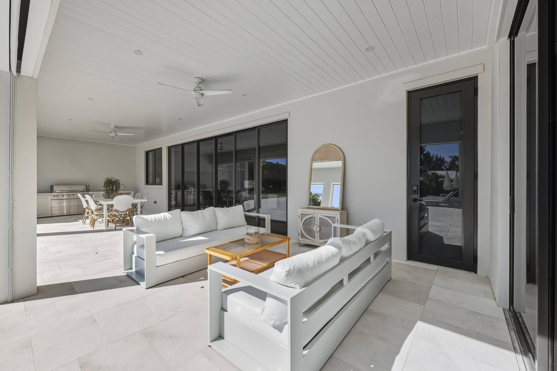 Covered Loggia with t&g ceiling detail, 2 fans & sand blaster marble tiles - door provides access to Cabana bath