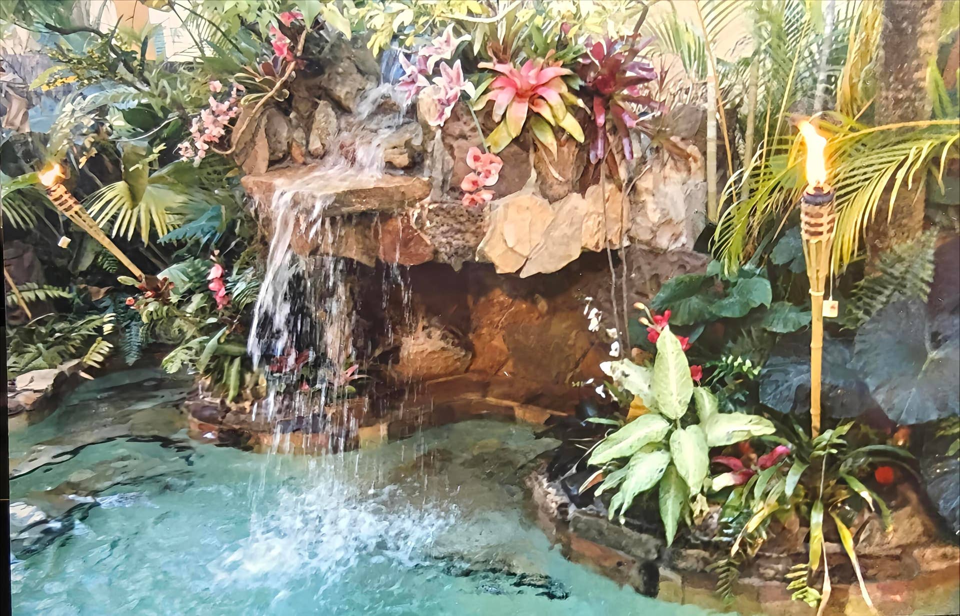 Waterfall pool led lit with tiki torches