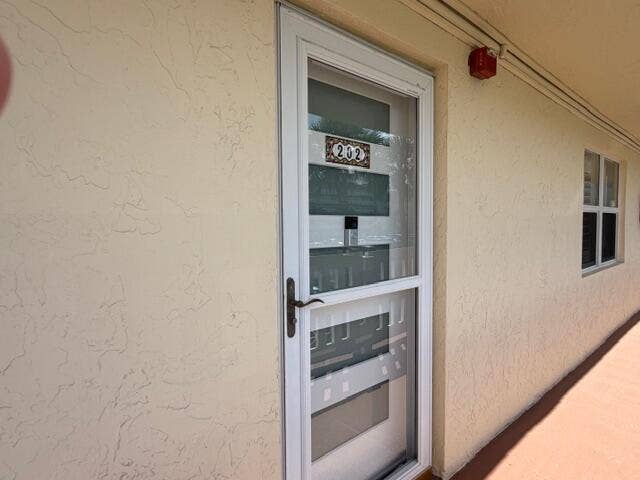 New front door with glass storm door and guest bedroom window