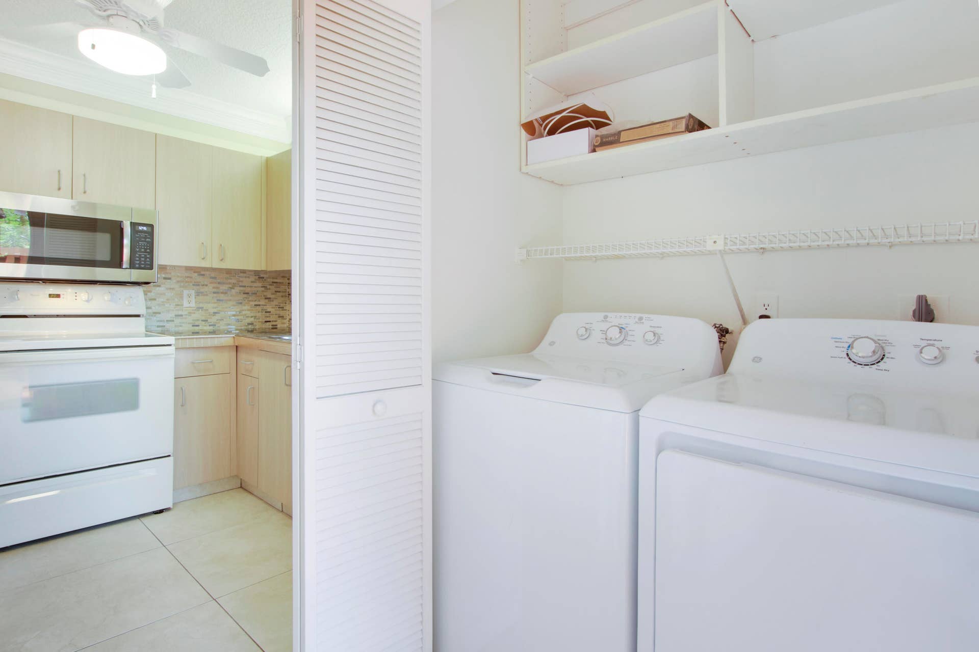 326 Jupiter Lakes Boulevard, #2318d, Jupiter, FL 33458 The laundry machines are tucked away in a closet near the kitchen.