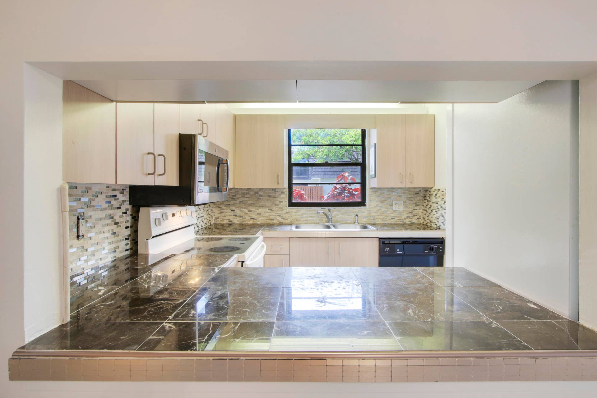 326 Jupiter Lakes Boulevard, #2318d, Jupiter, FL 33458 There is an open window from the kitchen to the dining area.