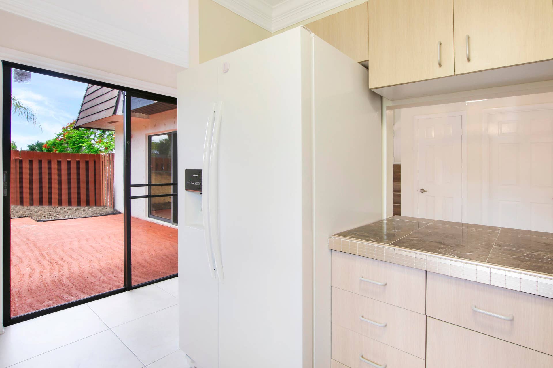 326 Jupiter Lakes Boulevard, #2318d, Jupiter, FL 33458 The kitchen offers a sliding glass door out to the patio.