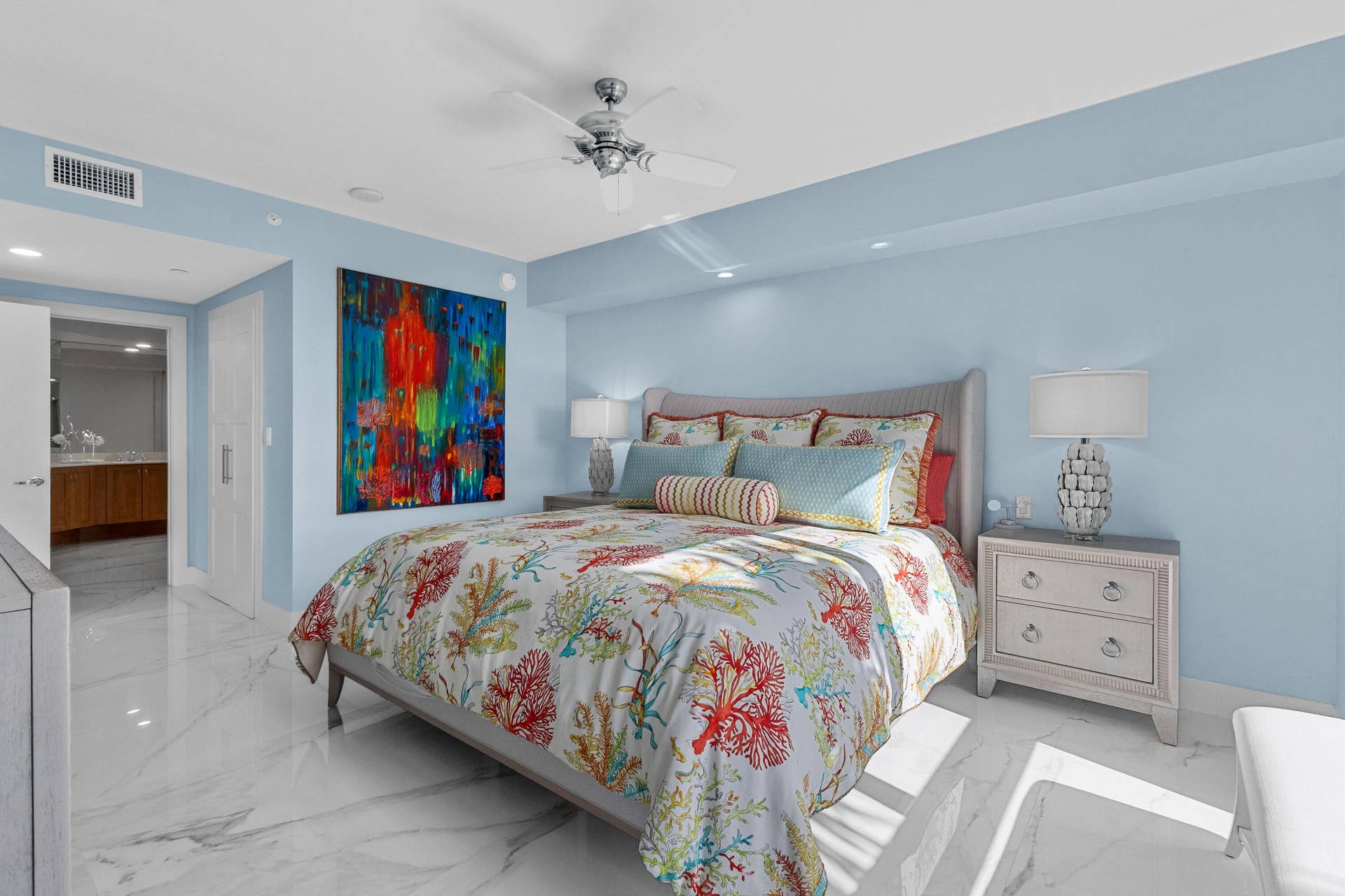 primary bedroom with a walk in closet, full bathroom and natural light.