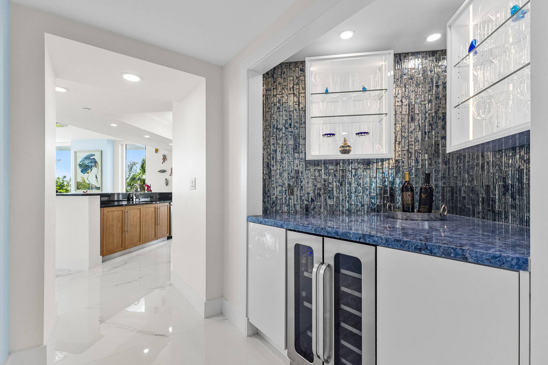 entertain family & friends in style with a custom built wet bar with wine fridge located off the kitchen with shelves to display your favorites.