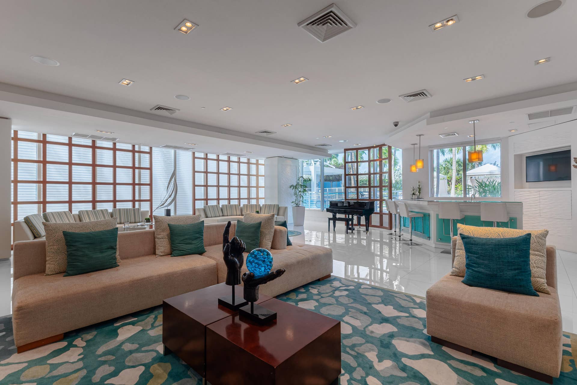 club house equipped with bar, kitchen, seating, access to the pool area, and seating with tv to host.