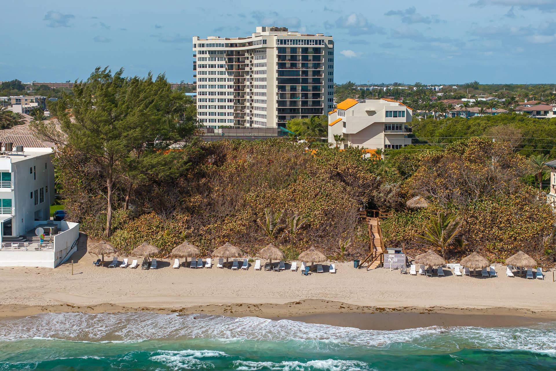View of lounges & umbrellas on private beach area.