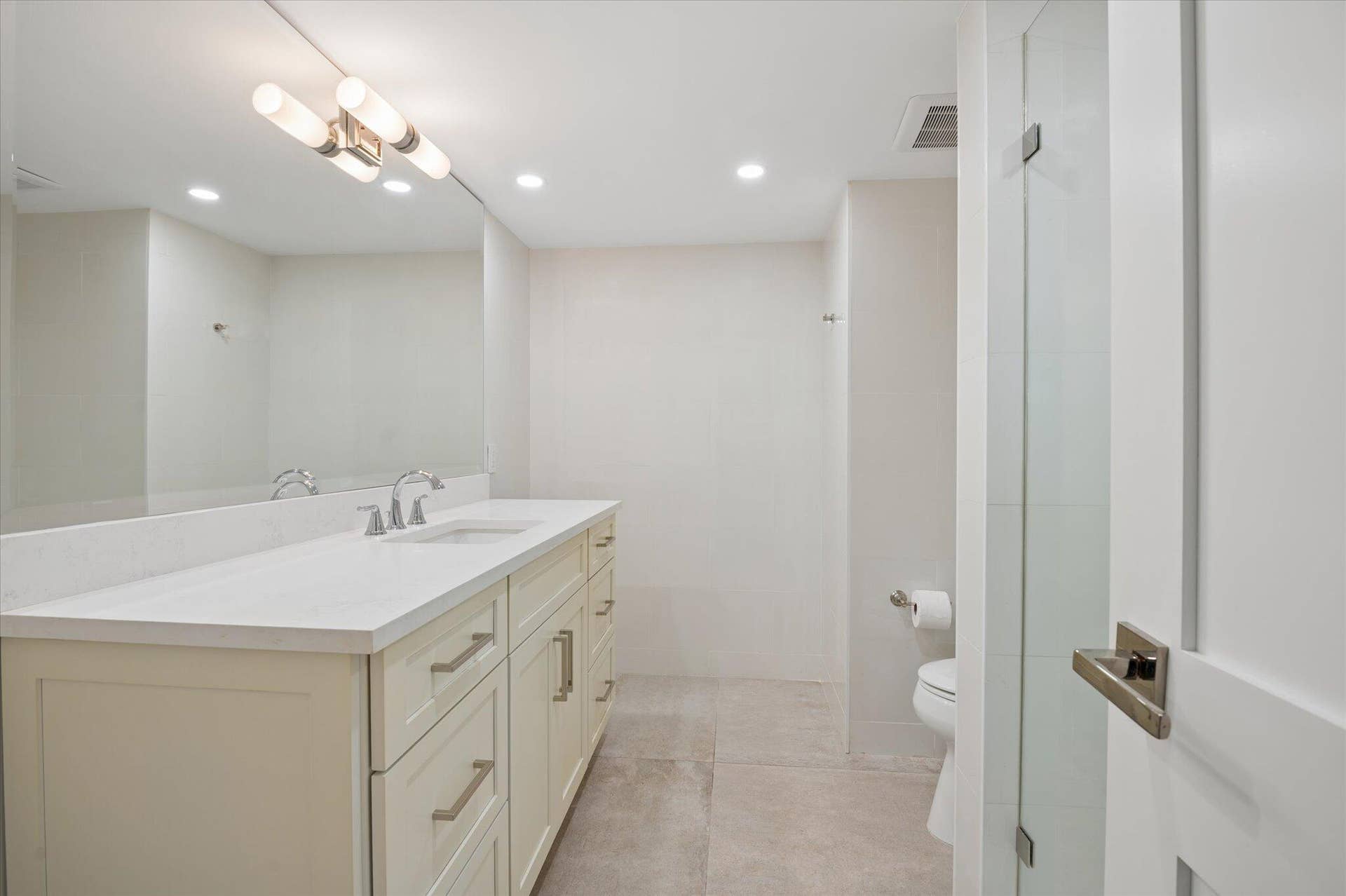 5100 Bayview Drive, #106, Fort Lauderdale, FL 33308 Updated bathroom with quartz countertops, shaker cabinetry, and contemporary lighting.