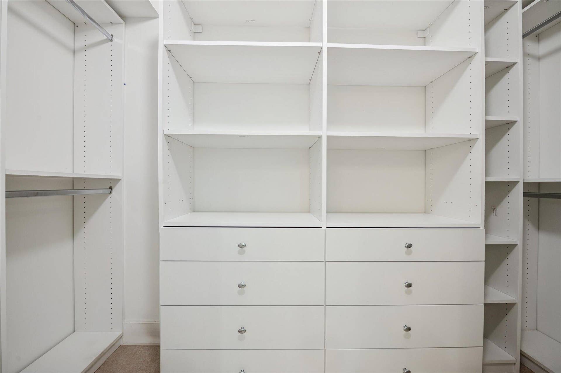 5100 Bayview Drive, #106, Fort Lauderdale, FL 33308 Custom walk-in closet with built-in shelving, drawers, and ample hanging space for optimal organization.