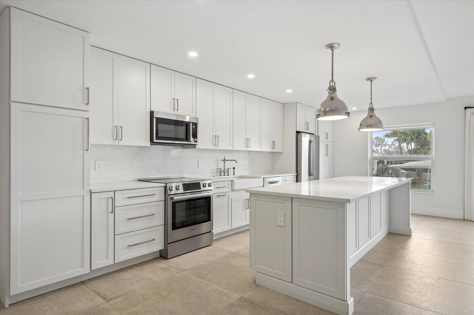 5100 Bayview Drive, #106, Fort Lauderdale, FL 33308 Custom-built kitchen with quartz countertops, shaker cabinetry, and a spacious center island with bar seatingdesigned for both everyday living and effortless entertaining.