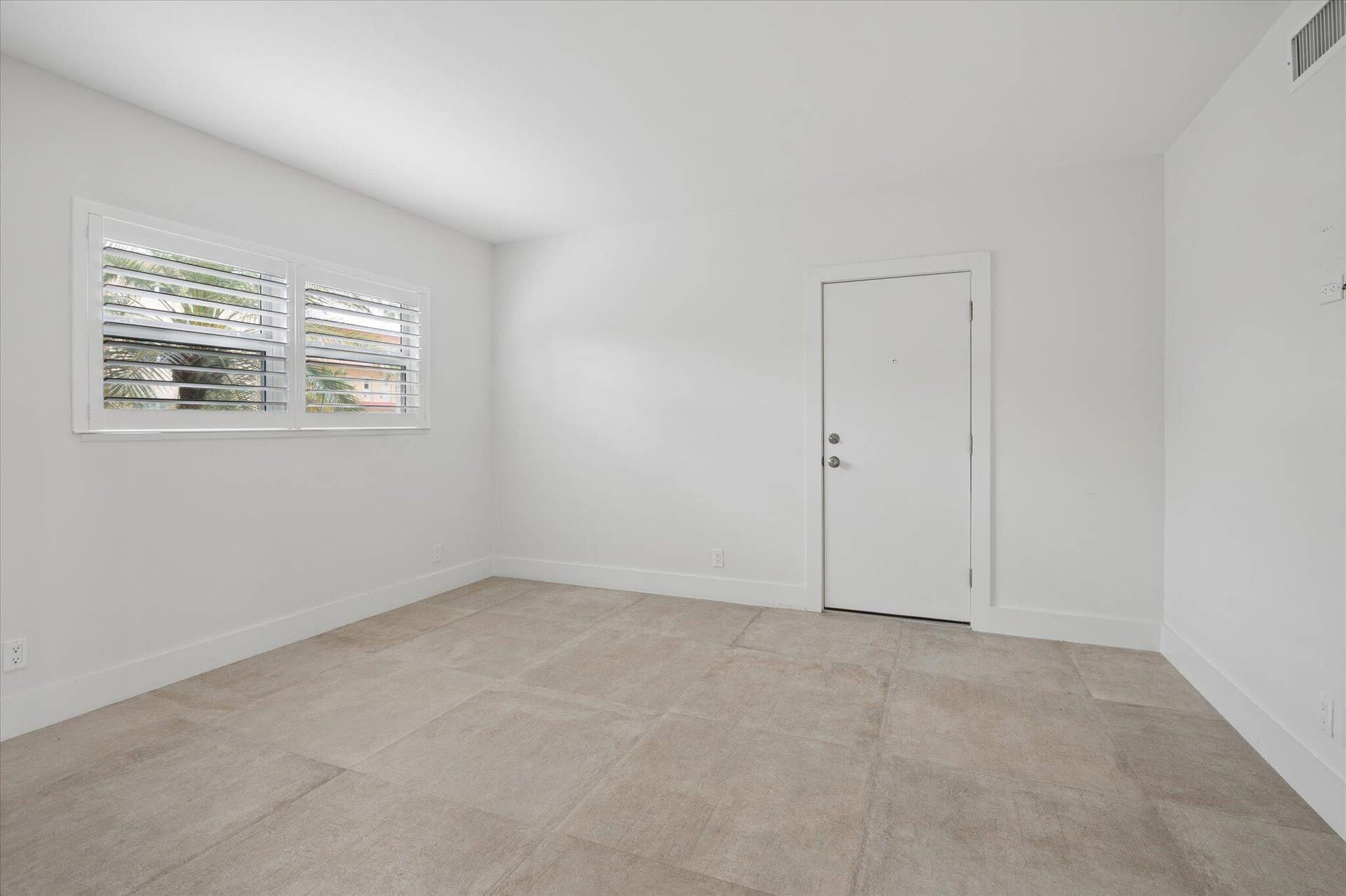 5100 Bayview Drive, #106, Fort Lauderdale, FL 33308 Bright and airy bedroom featuring plantation shutters and neutral tile flooring throughout.