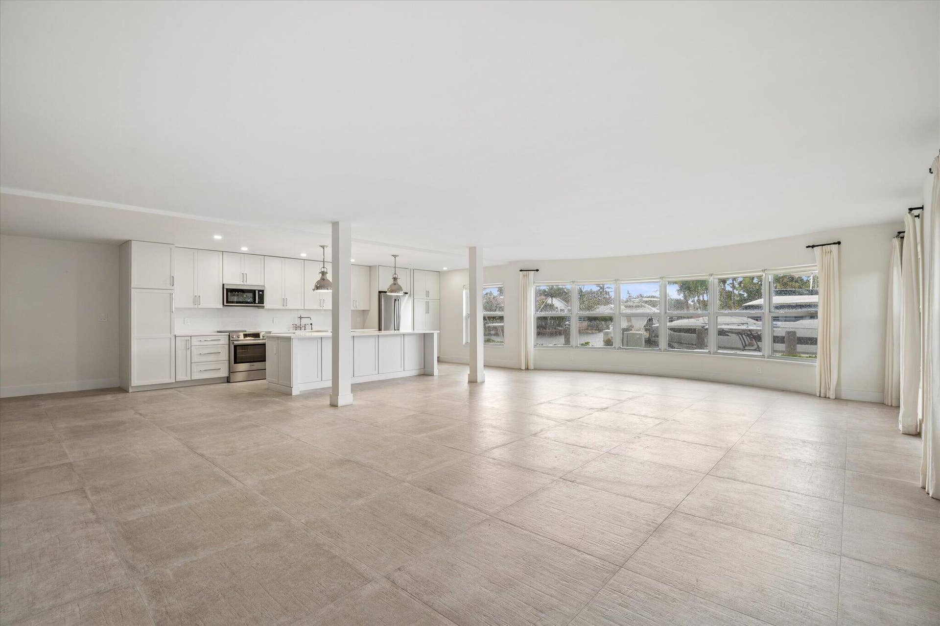 5100 Bayview Drive, #106, Fort Lauderdale, FL 33308 Expansive living space with a wall of bay windows showcasing panoramic canal viewsthis oversized 1,835 sq ft layout offers exceptional versatility, allowing for multiple dining and seating configurations rarely found in a 2BR/2BA condo.