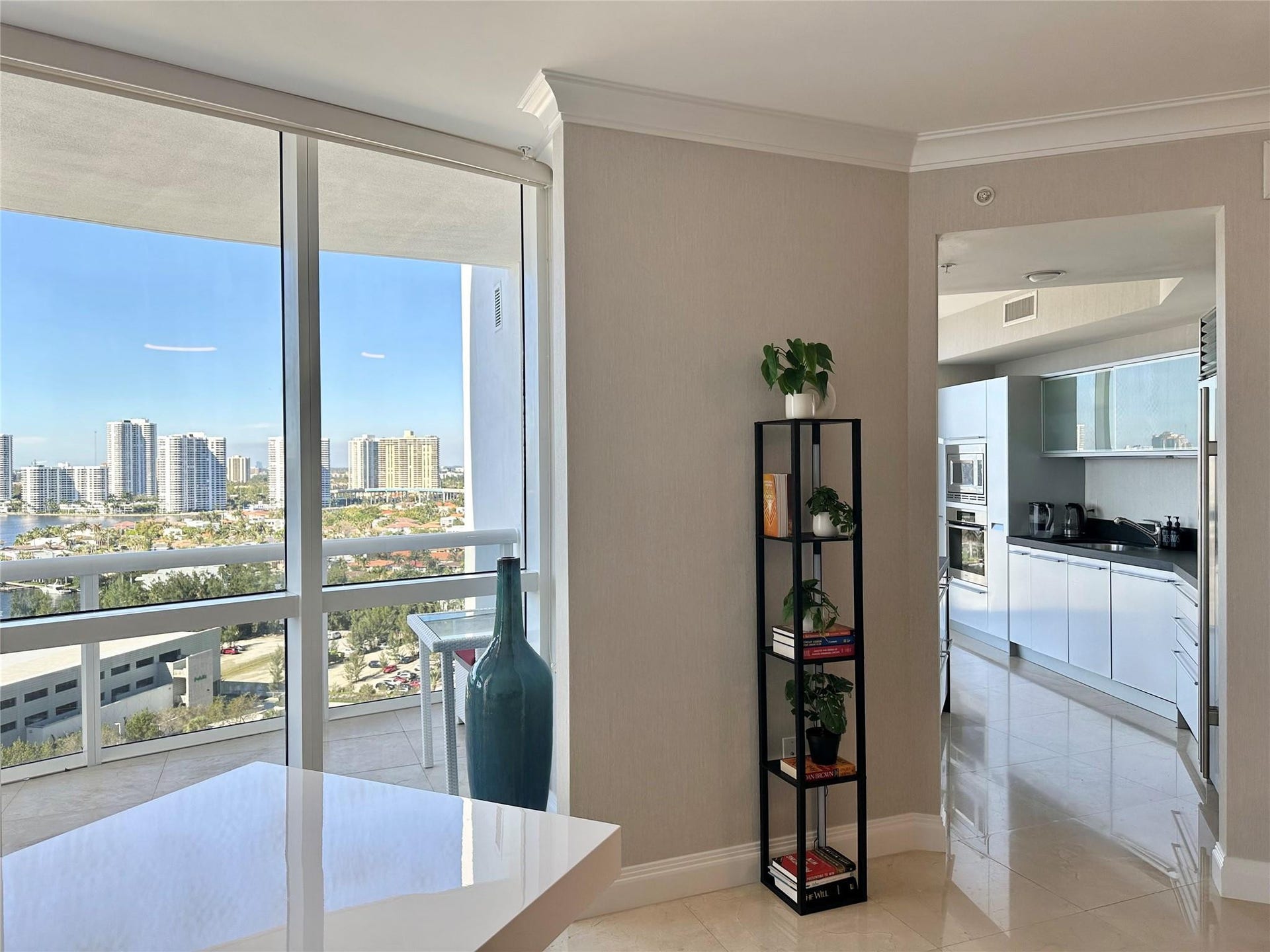 entrance to kitchen and view to balcony from living