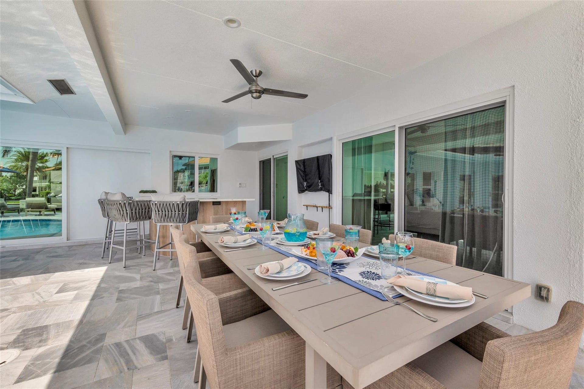 Covered Patio and Outdoor Bar area with outdoor dining fro 8, bar area, TV, Putting Green and amazing canal & intercostal views.