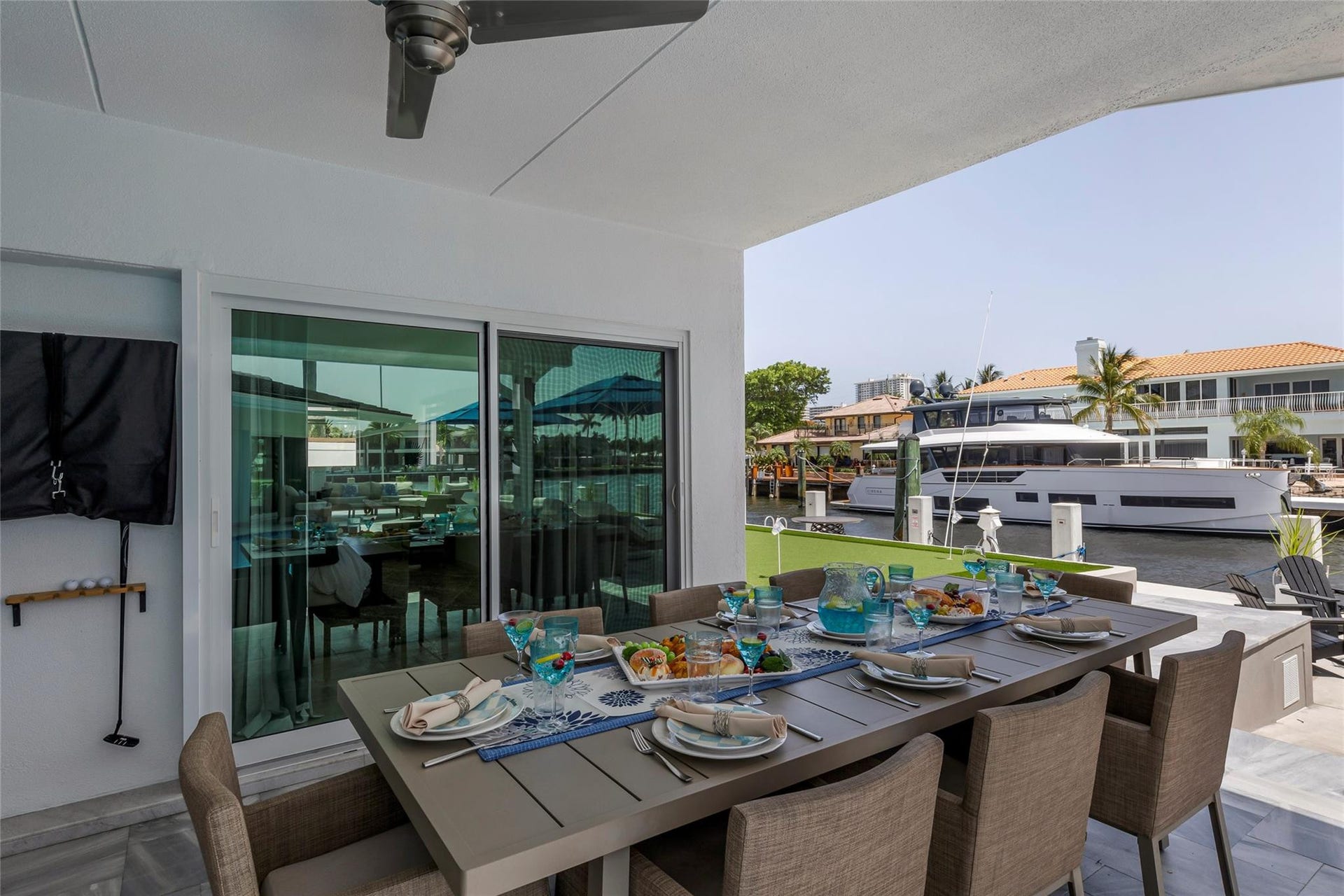 Covered Patio and Outdoor Bar area with outdoor dining fro 8, bar area, TV, Putting Green and amazing canal & intercostal views.