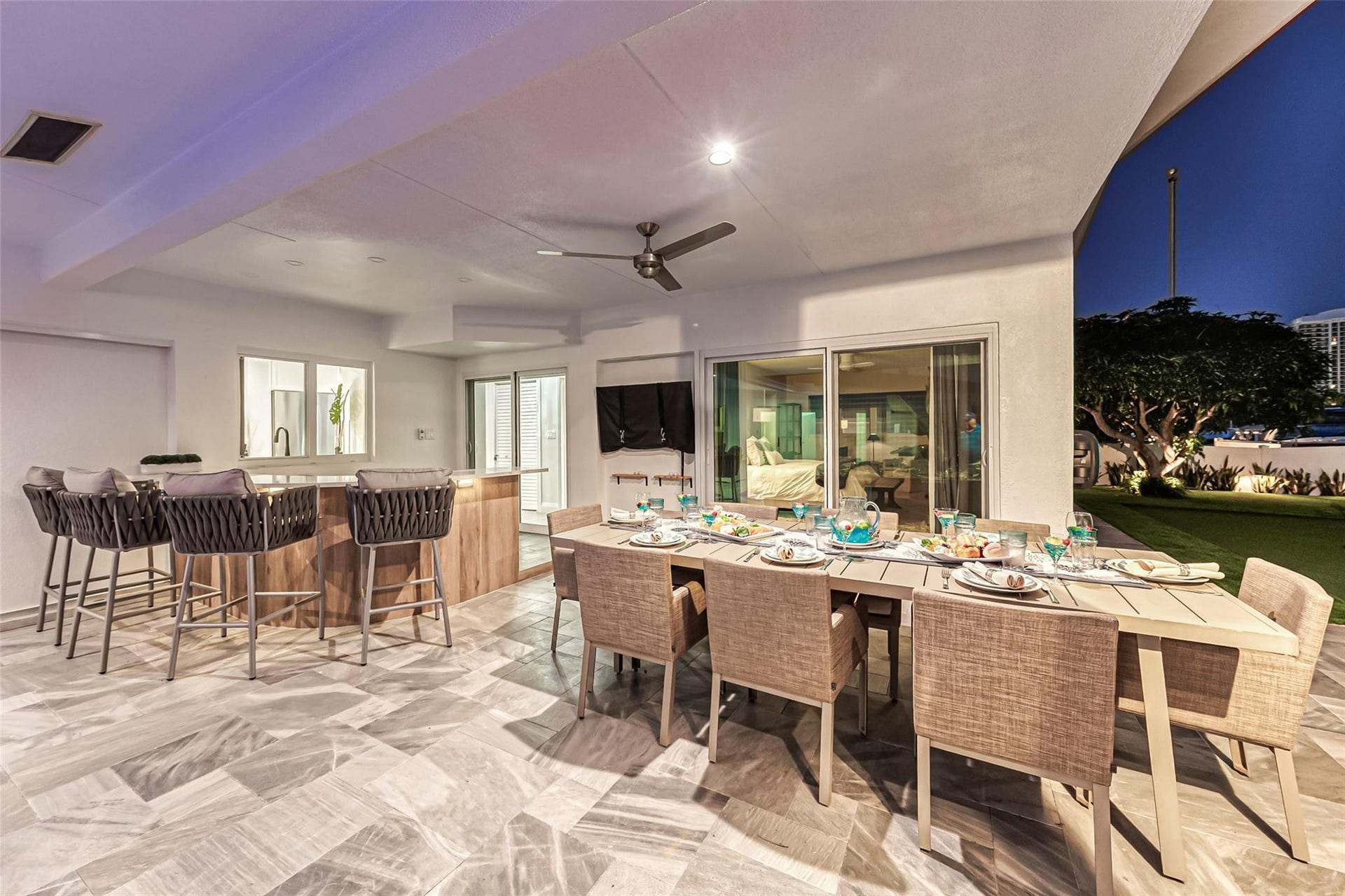 Covered Patio and outdoor bar area with outdoor dining for 8, bar area, TV, Putting Green and amazing canal & intercostal views.