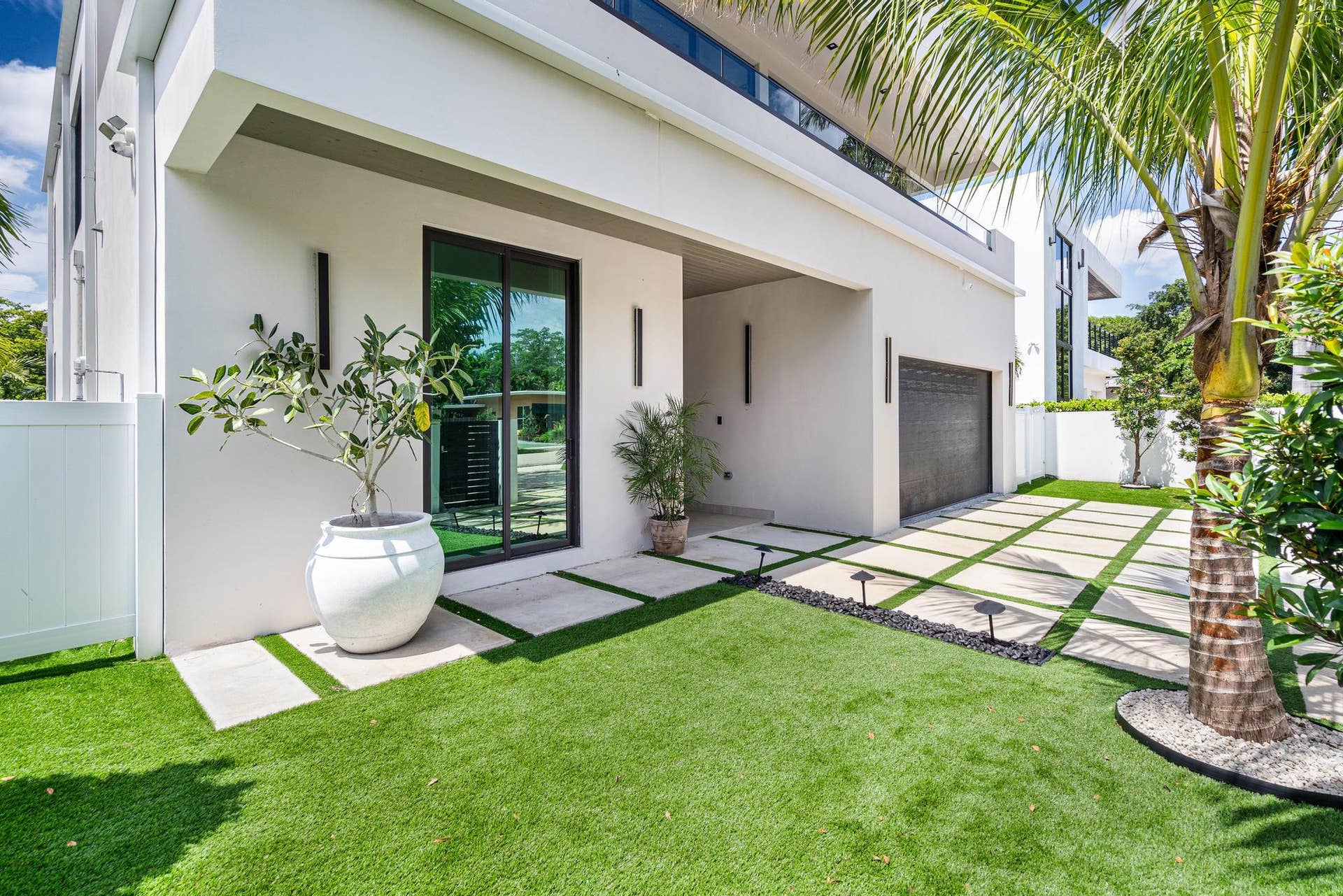 View of the grand front entrance framed by lush landscaping and manicured turf.