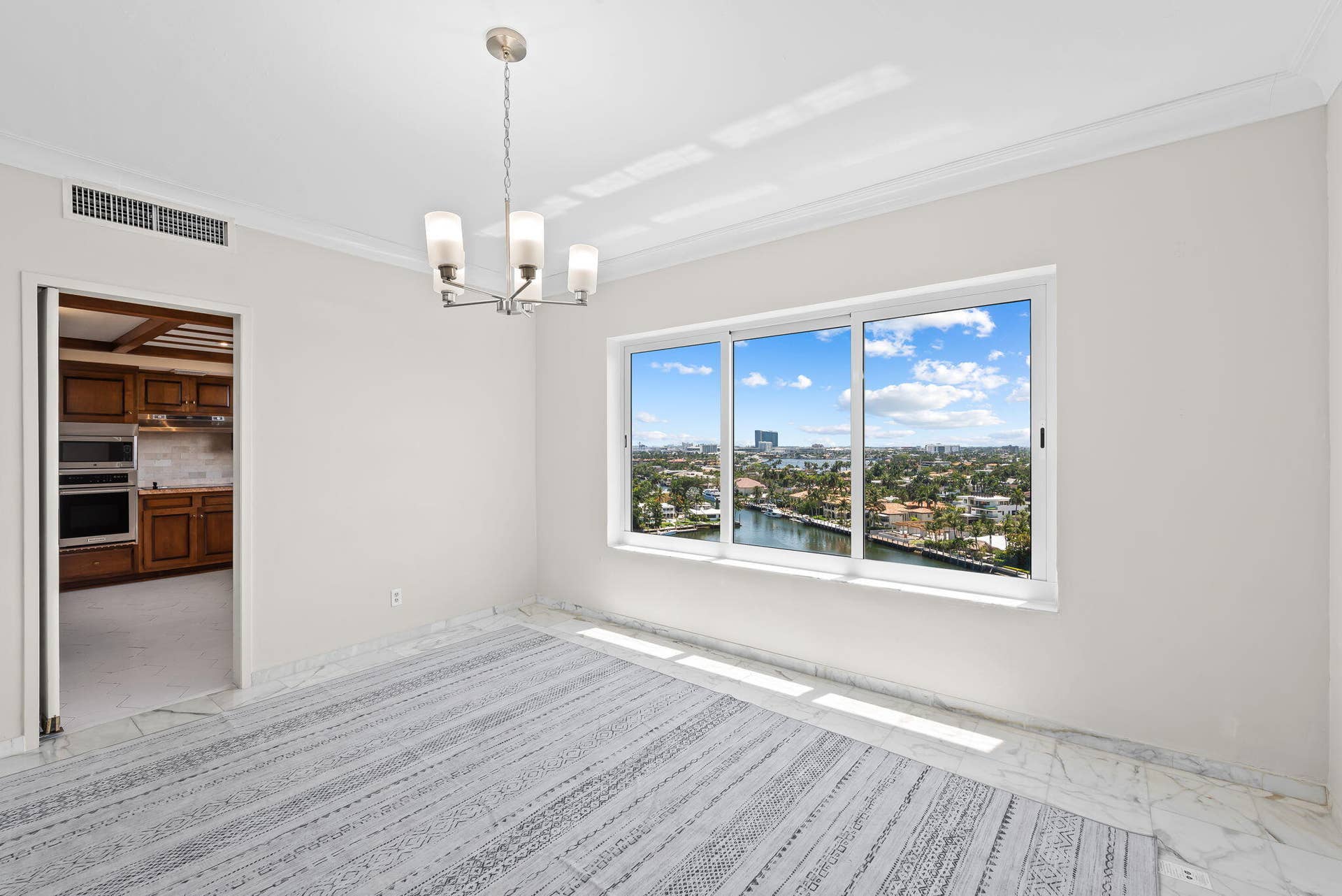 Dining room with view over the lake and las Olas waterfront homes - kitchen off to the side