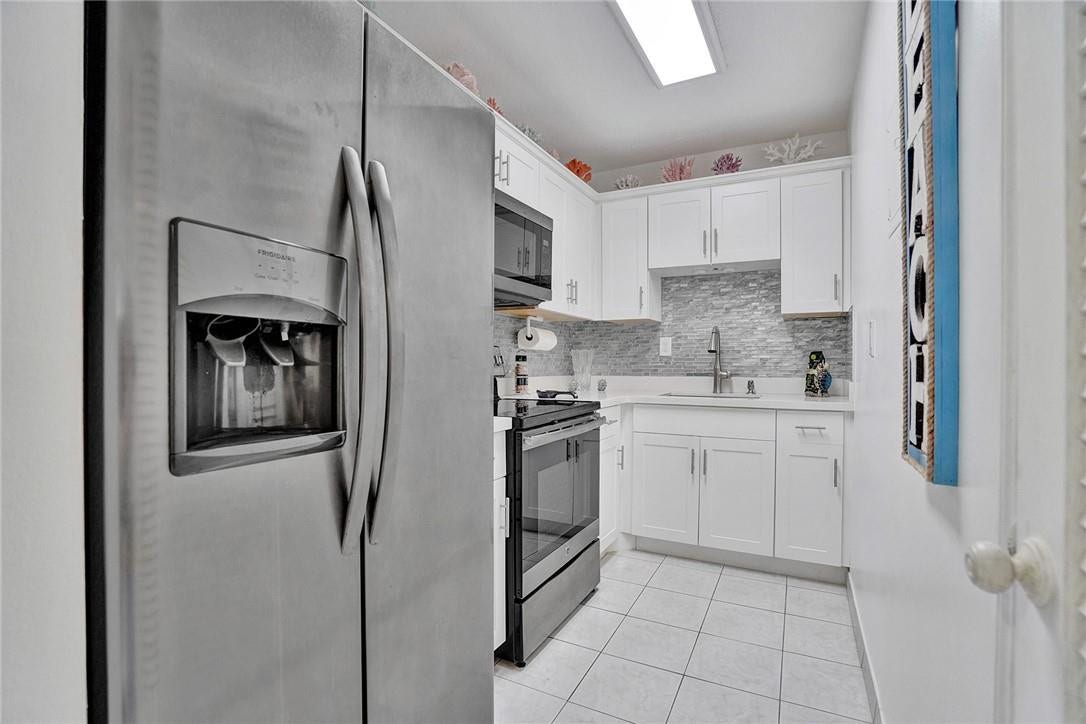 Updated Kitchen with Stainless Appliances and Glass Backsplash.