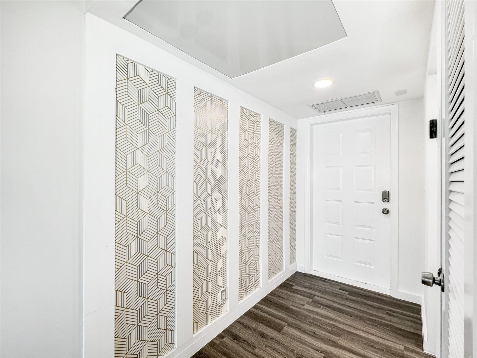 2950 N Palm Aire Drive, #506, Pompano Beach, FL 33069 Entry hallway showcases vinyl flooring, modern wall detailing, and a bright neutral color palette. Clean lines and updated finishes create a welcoming first impression.