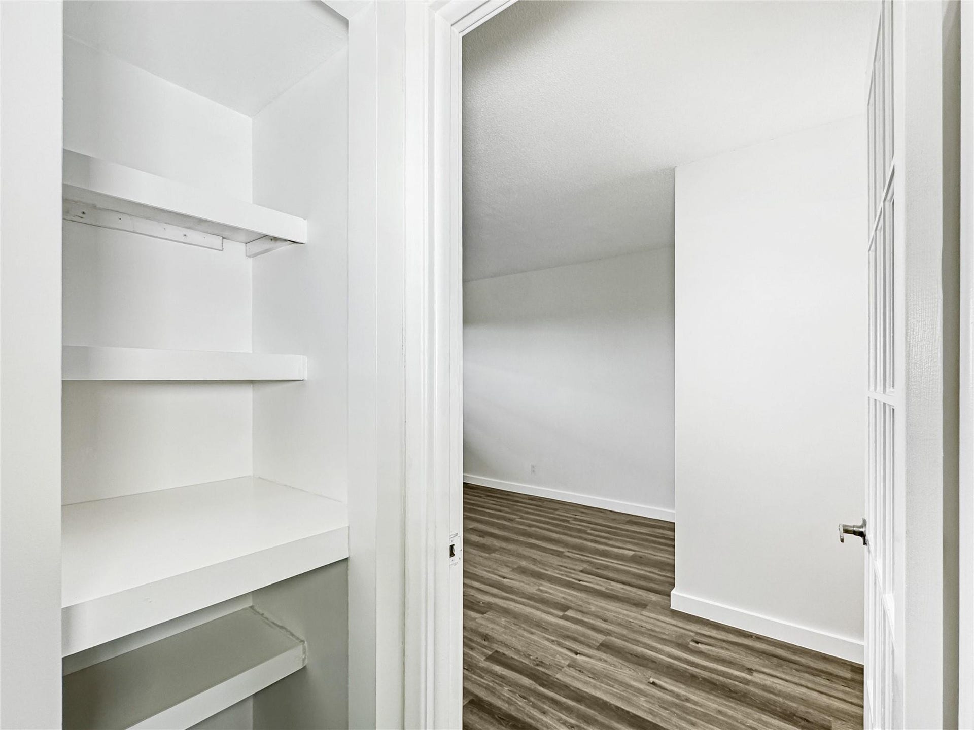 2950 N Palm Aire Drive, #506, Pompano Beach, FL 33069 Built-in shelving provides convenient additional storage and organization space. Adjacent window-paned doors and vinyl flooring continue the homes cohesive design.