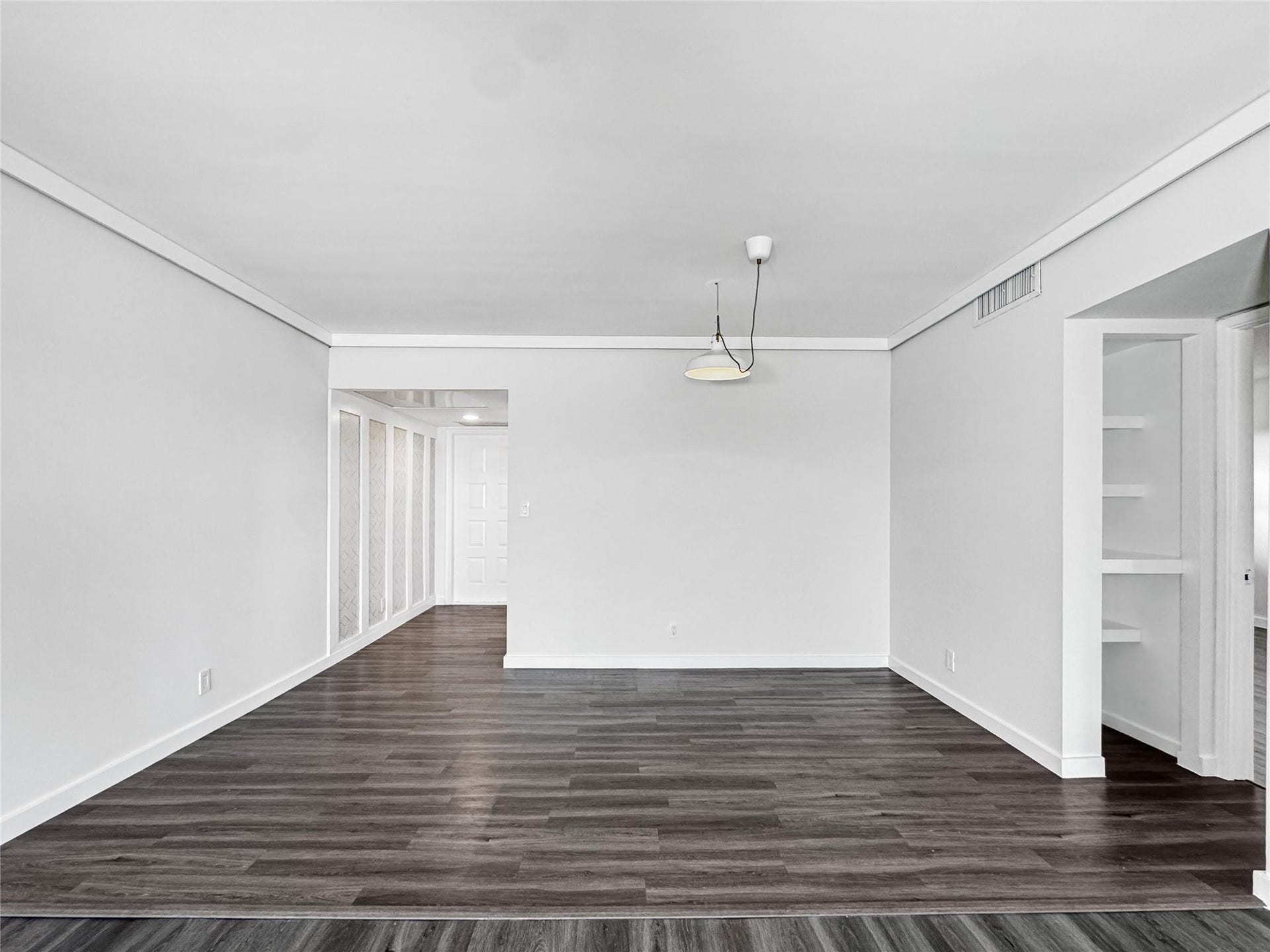2950 N Palm Aire Drive, #506, Pompano Beach, FL 33069 Spacious living and dining area features updated vinyl flooring, neutral finishes, and an open layout designed for flexible everyday living and entertaining. Built-in shelving and clean architectural lines add both function and visual appeal.