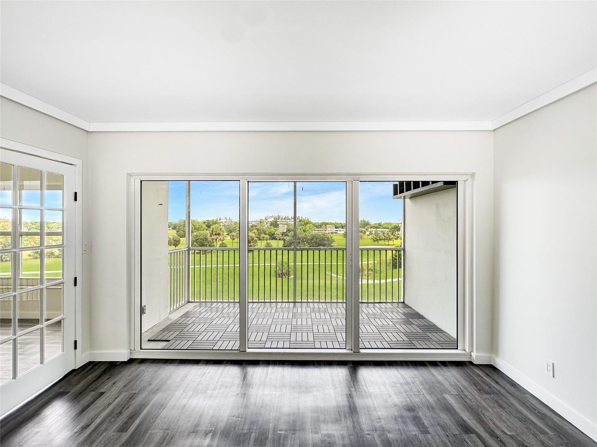 2950 N Palm Aire Drive, #506, Pompano Beach, FL 33069 Large sliding glass doors frame the screened balcony and open views of the surrounding golf course, extending the living space outdoors with a bright, open feel.
