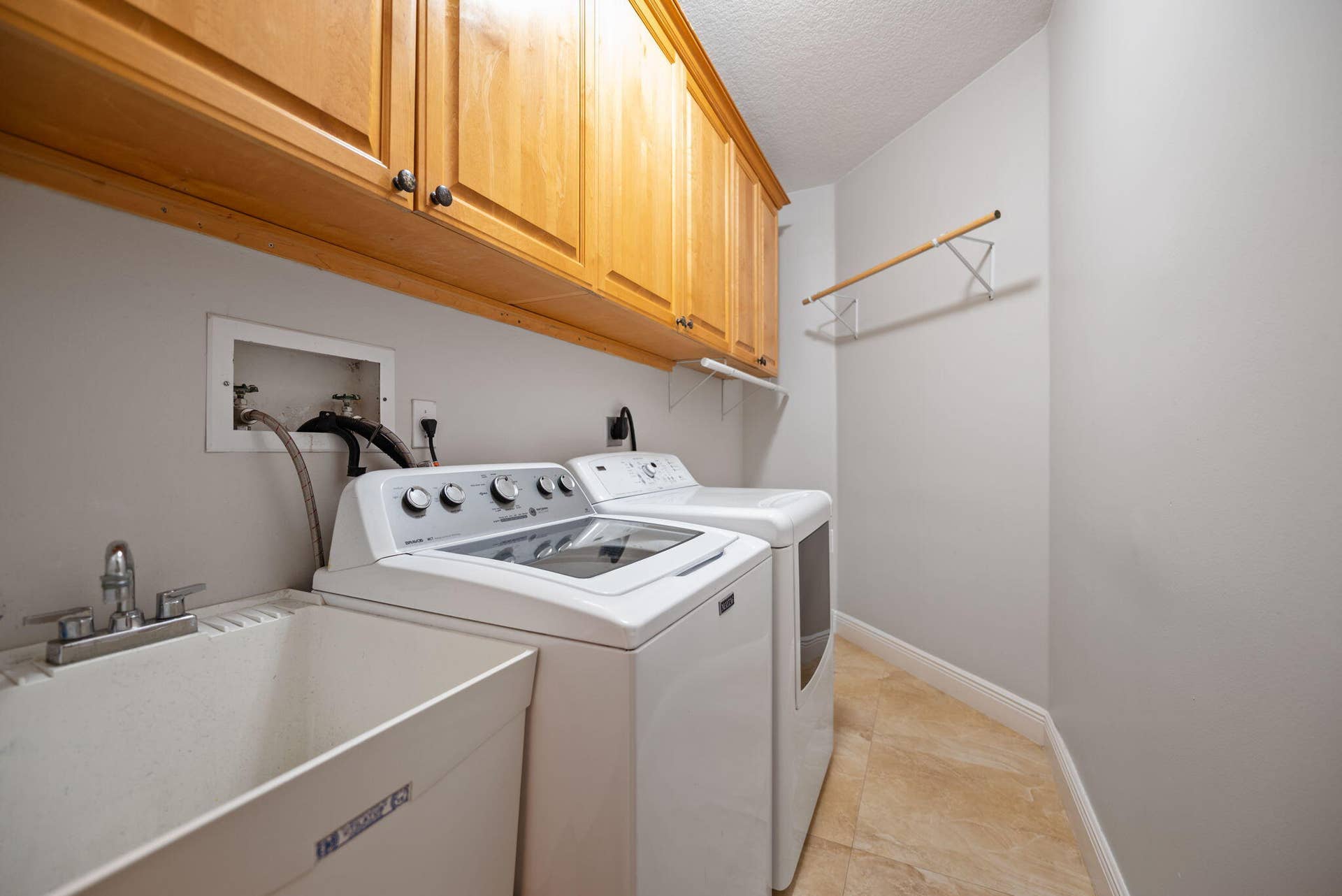 Laundry room with lots of cabinet storage and clothes hanging space plus floor space for 3 laundry baskets back in the corner. And a storage room off to the right.