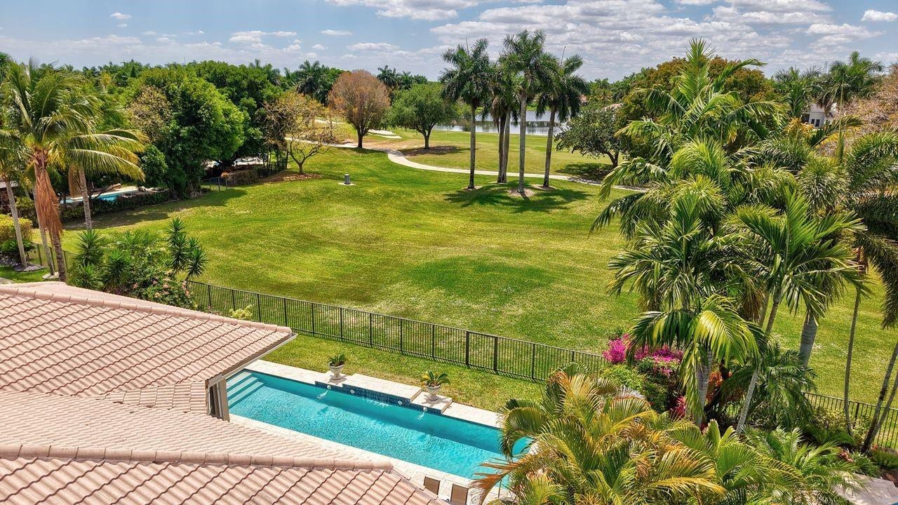 2491 Eagle Run Drive, Weston, FL 33327 How's this for your backyard views?! Live the peaceful country club life with these spectacular golf and lake views as an extension of your own fenced backyard wit modern HEATED pool!