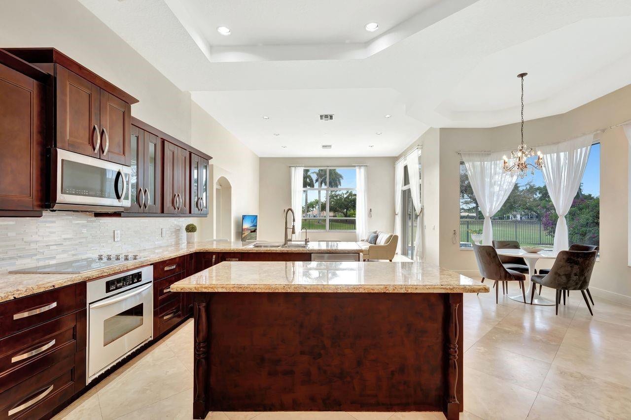 2491 Eagle Run Drive, Weston, FL 33327 Brand new stainless steel appliances, solid wood cabinetry, large center island, a backsplash with lighting that changes for your mood, granite counters, walk-in pantry and breathtaking views!