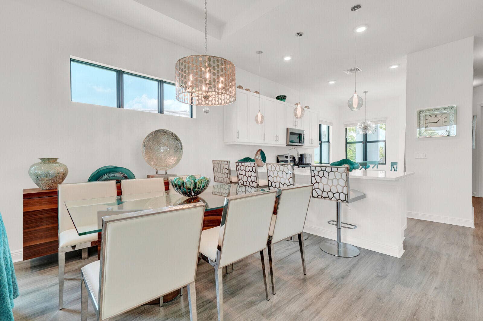 Open-concept living space featuring wood-finish flooring, a contemporary chandelier, recessed lighting, and high transom windows