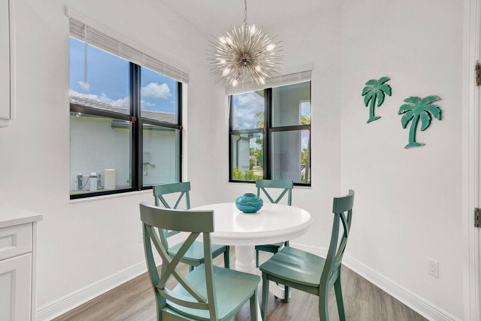 Dining area featuring white walls, wood-finish flooring, and a contemporary sputnik-style chandelier
