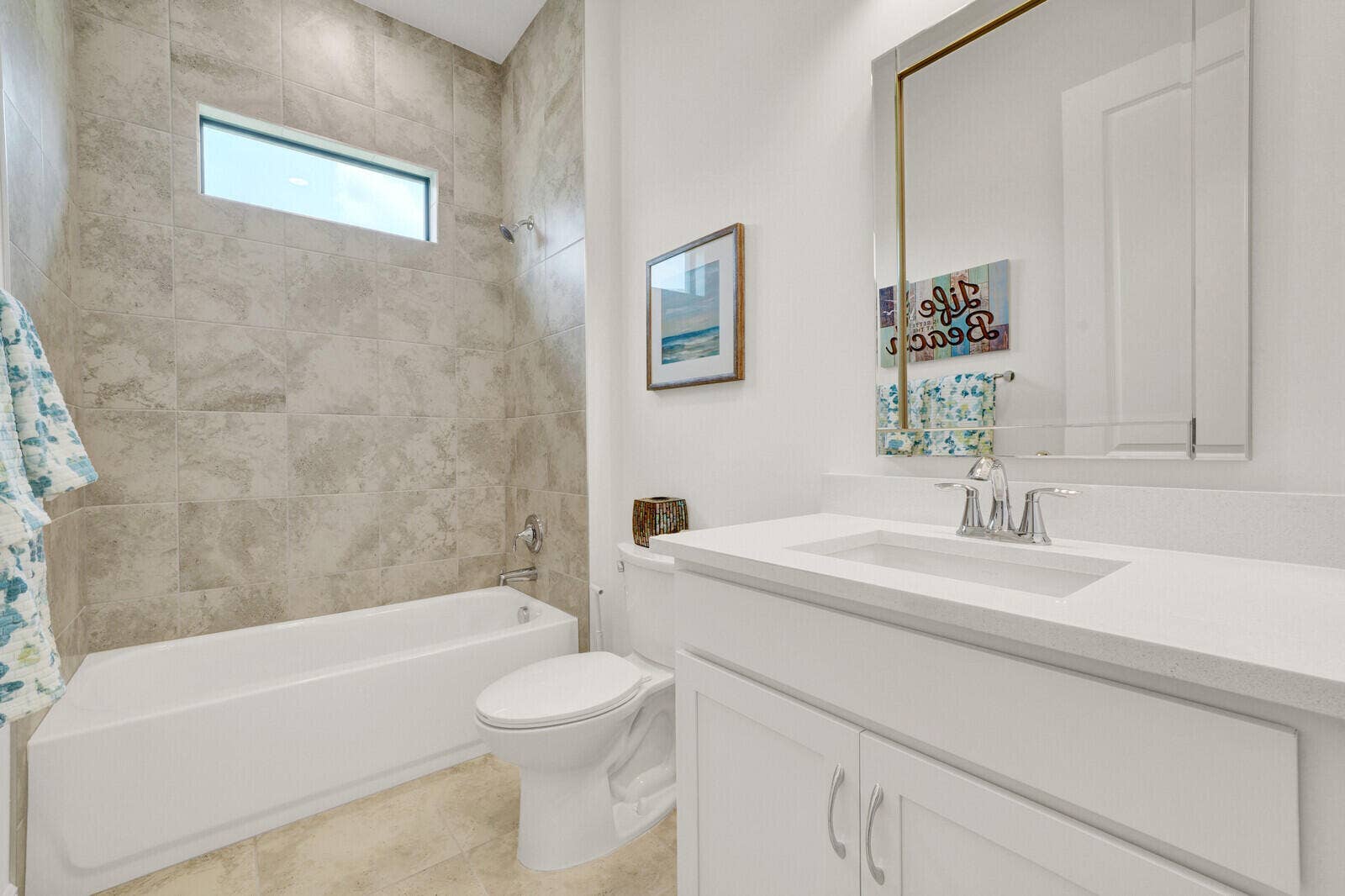 Bathroom featuring a white vanity with a light-toned countertop, an undermount sink, and a framed mirror