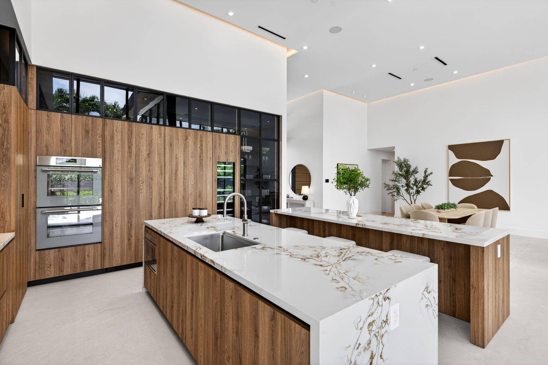 2717 NE 33rd Street, Fort Lauderdale, FL 33306 A refined kitchen view highlights generous prep areas, warm cabinetry, elegant stone surfaces, and strong indoor-outdoor flow.