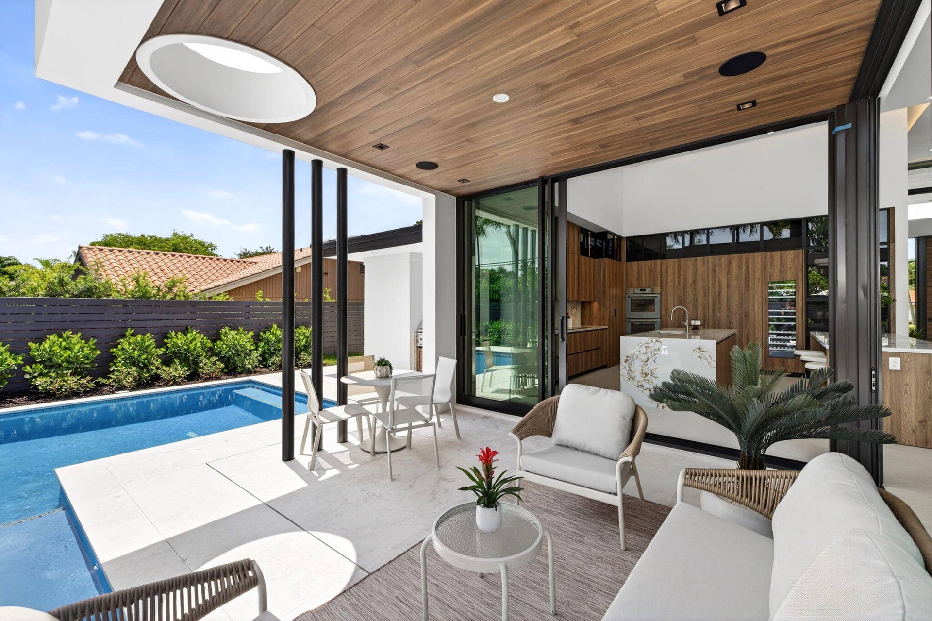 2717 NE 33rd Street, Fort Lauderdale, FL 33306 Covered outdoor living extends the residence to the private pool, summer kitchen, and fully fenced tropical grounds.