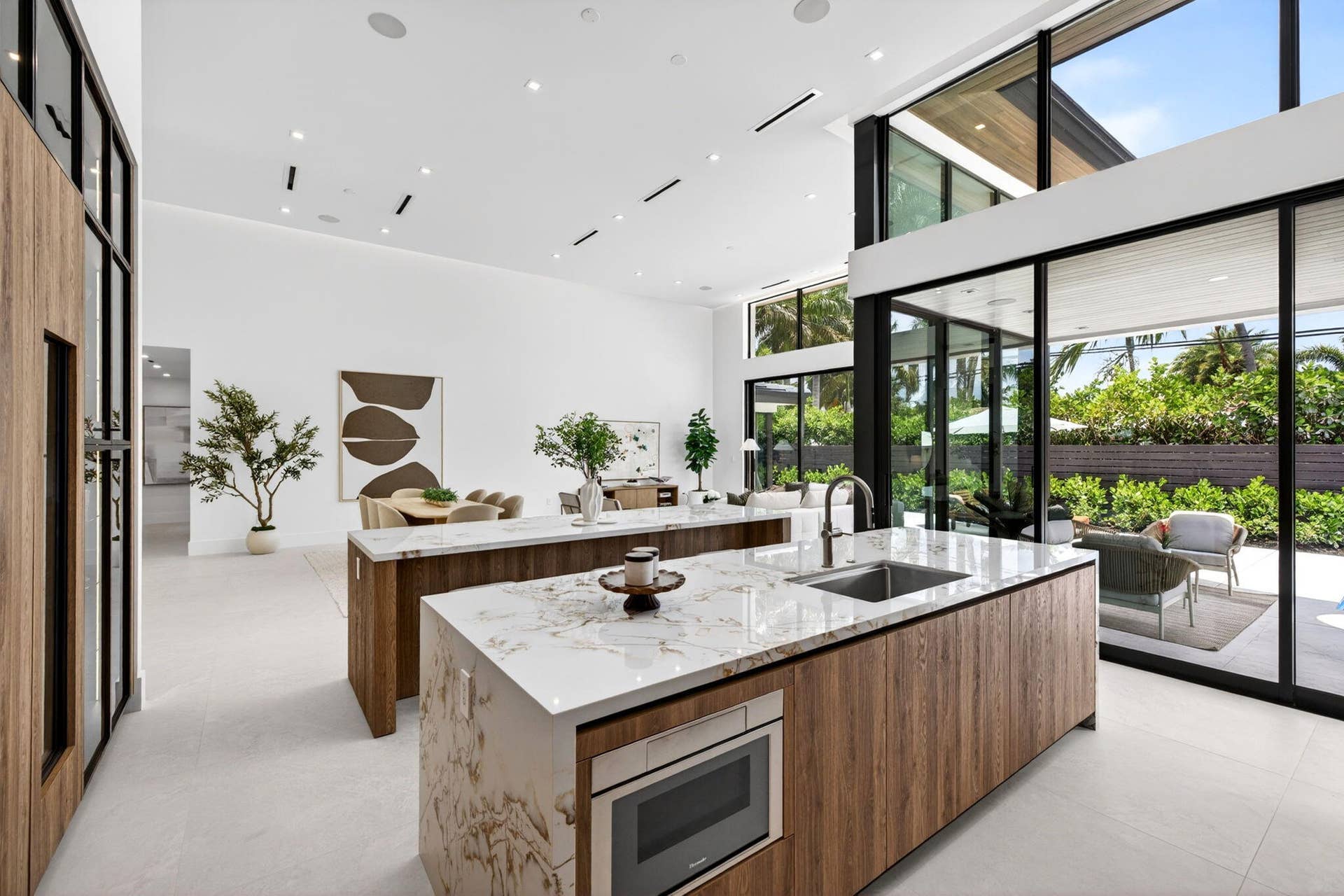 2717 NE 33rd Street, Fort Lauderdale, FL 33306 A refined kitchen view highlights generous prep areas, warm cabinetry, elegant stone surfaces, and strong indoor-outdoor flow.