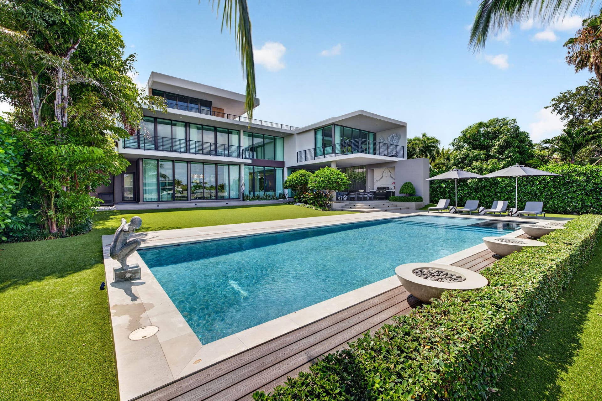 A resort-inspired waterfront property showcasing the 50-foot saltwater pool, manicured grounds, and striking contemporary rear elevation.