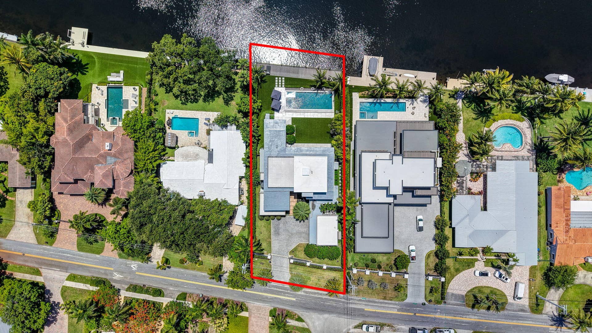 A commanding aerial perspective revealing the estates scale, premier riverfront position, manicured grounds, and coveted Coral Ridge setting.