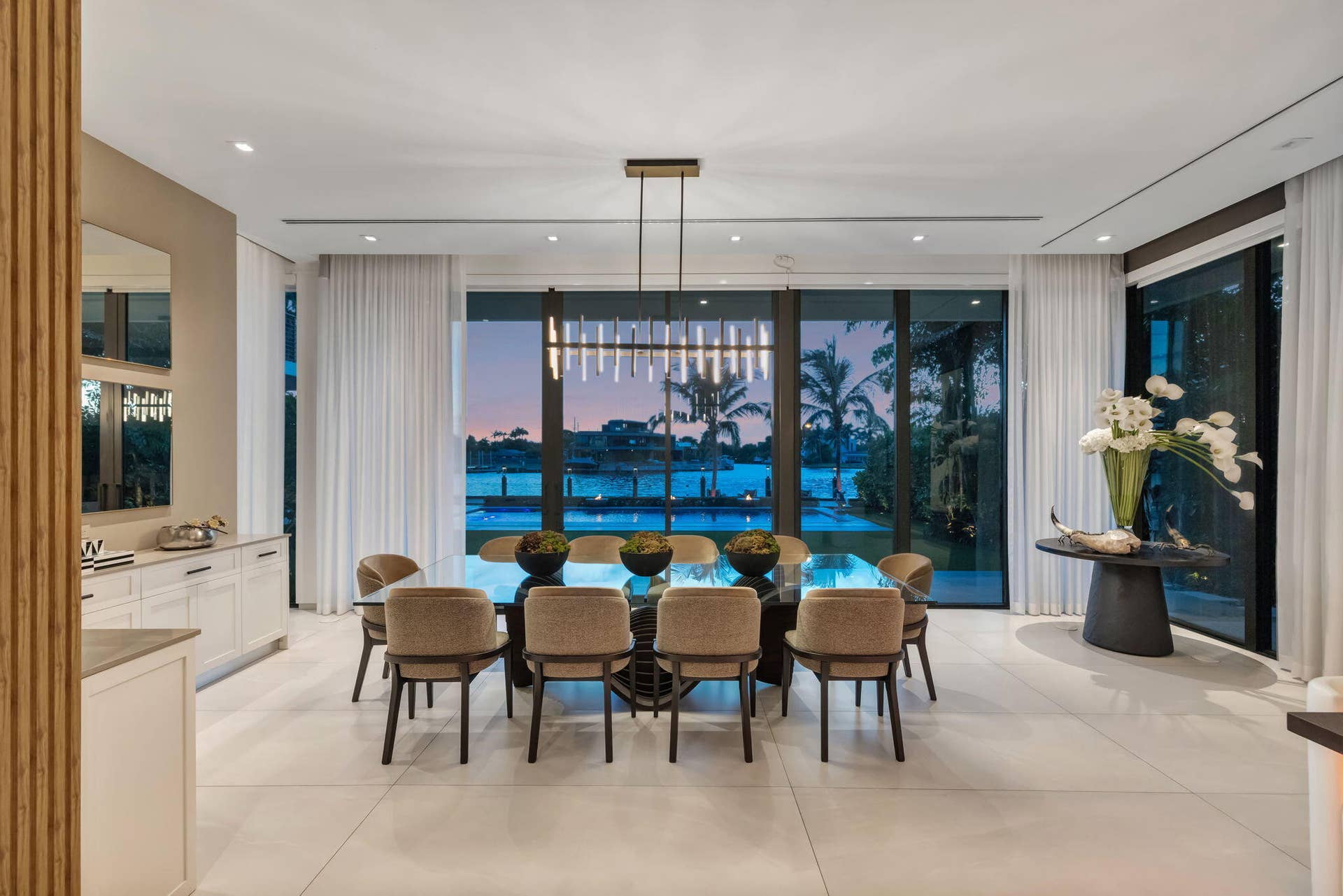 A sophisticated dining setting wrapped in natural light and river views, creating an elegant backdrop for intimate dinners and memorable entertaining.