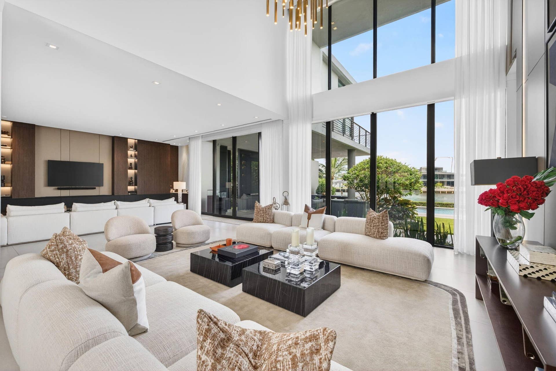 A dramatic, light-filled great room where soaring volume, refined finishes, and walls of glass frame the homes seamless connection to the Middle River lifestyle.