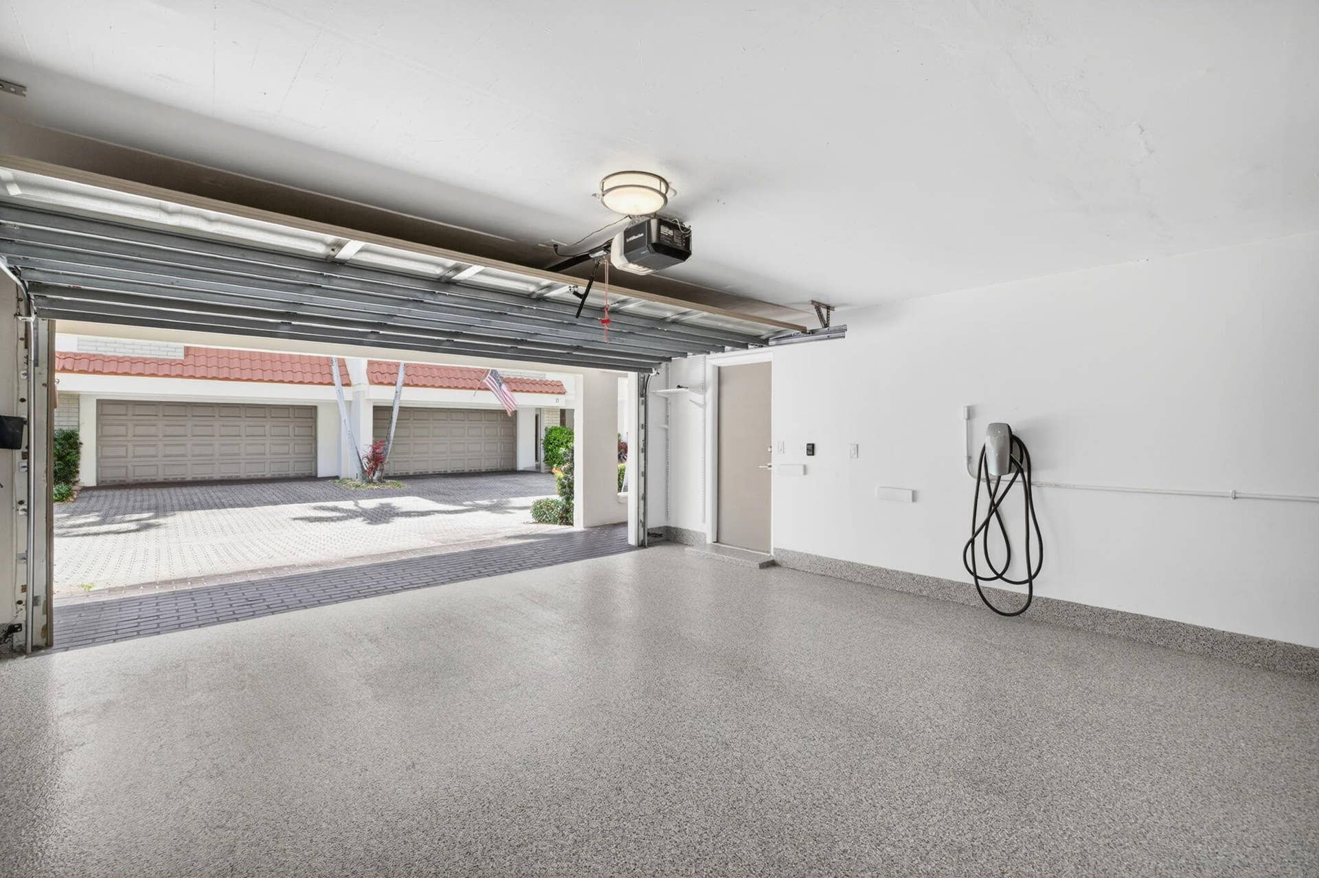 Attached 2-car garage with epoxy flooring and a Tesla EV charger