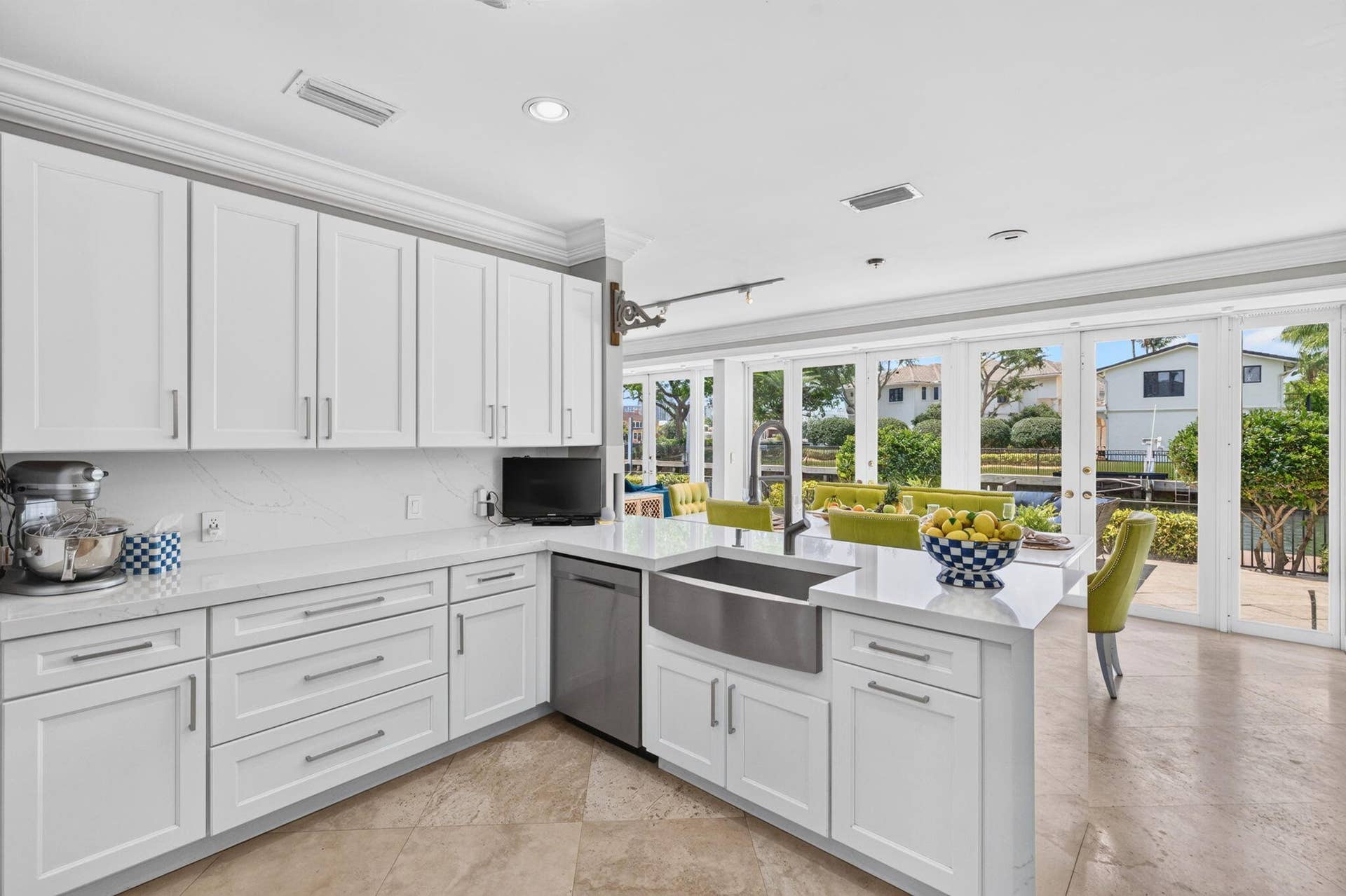 3110 NE 47th Street, Fort Lauderdale, FL 33308 Glass doors connect the kitchen to the terrace, keeping the waterfront and outdoor living areas in view.