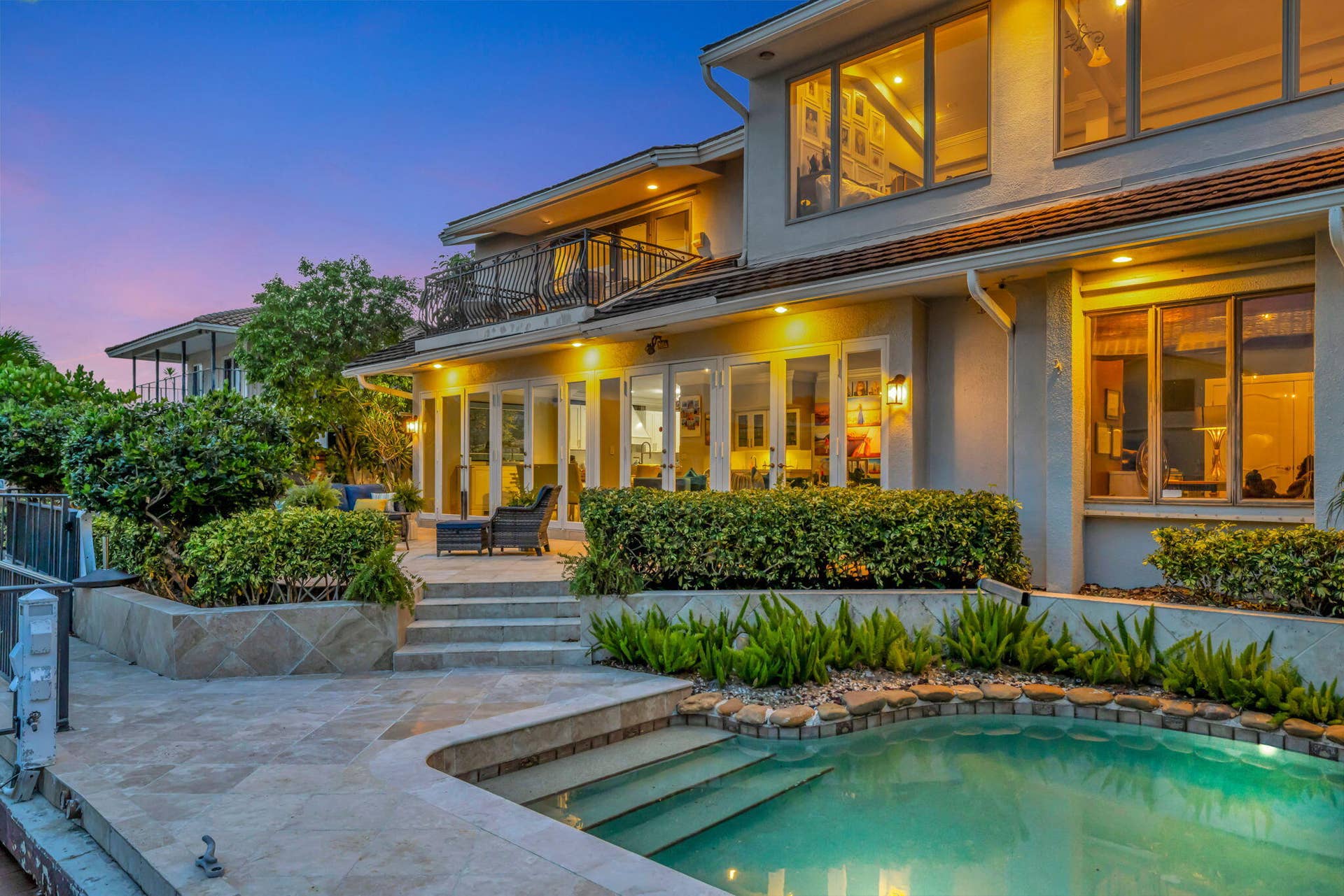 3110 NE 47th Street, Fort Lauderdale, FL 33308 The illuminated rear elevation, pool, and waterfront setting create a strong evening hero image.