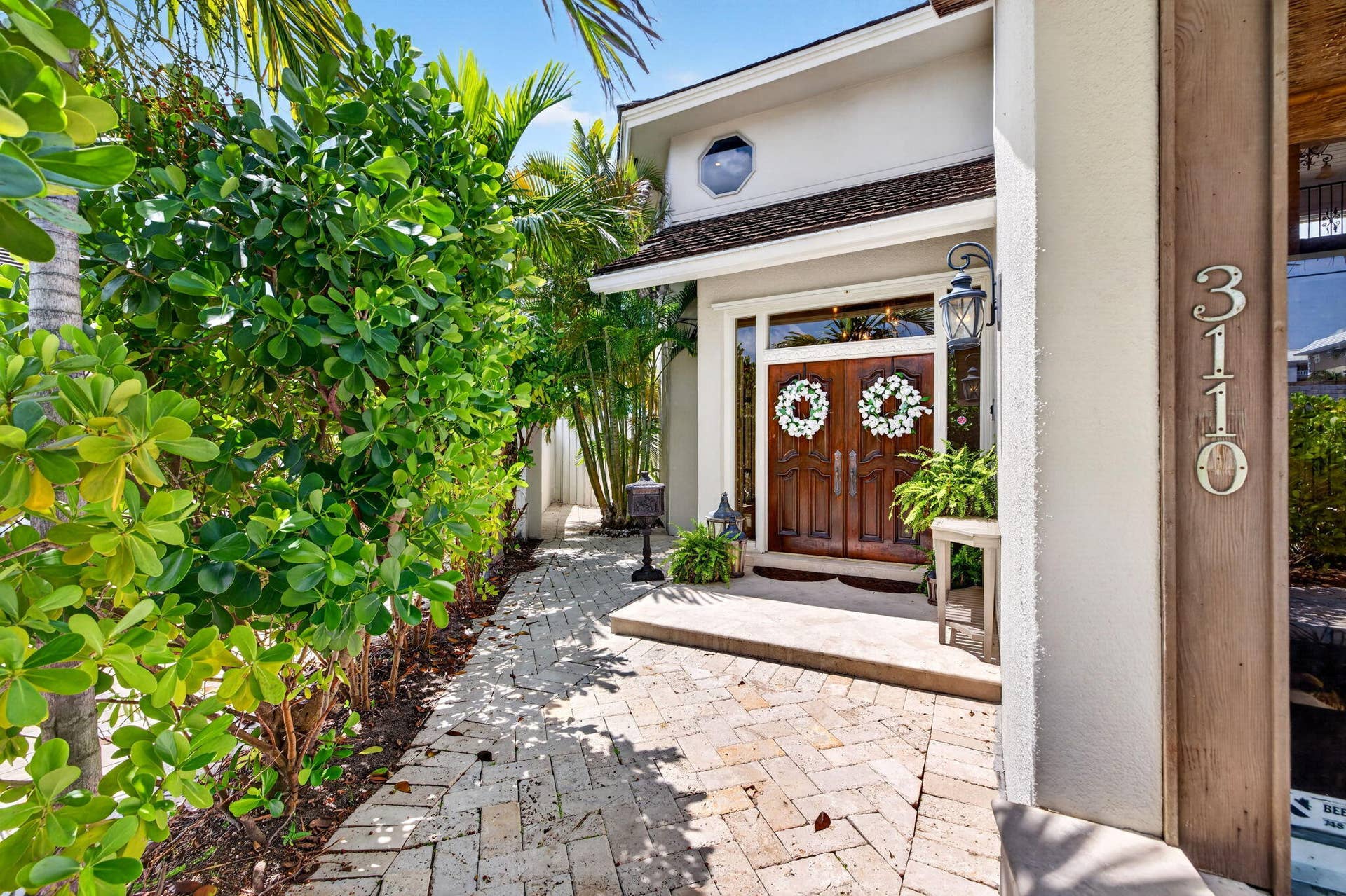 3110 NE 47th Street, Fort Lauderdale, FL 33308 A gracious front entry sets the tone with lush landscaping, double doors, and a refined arrival sequence.